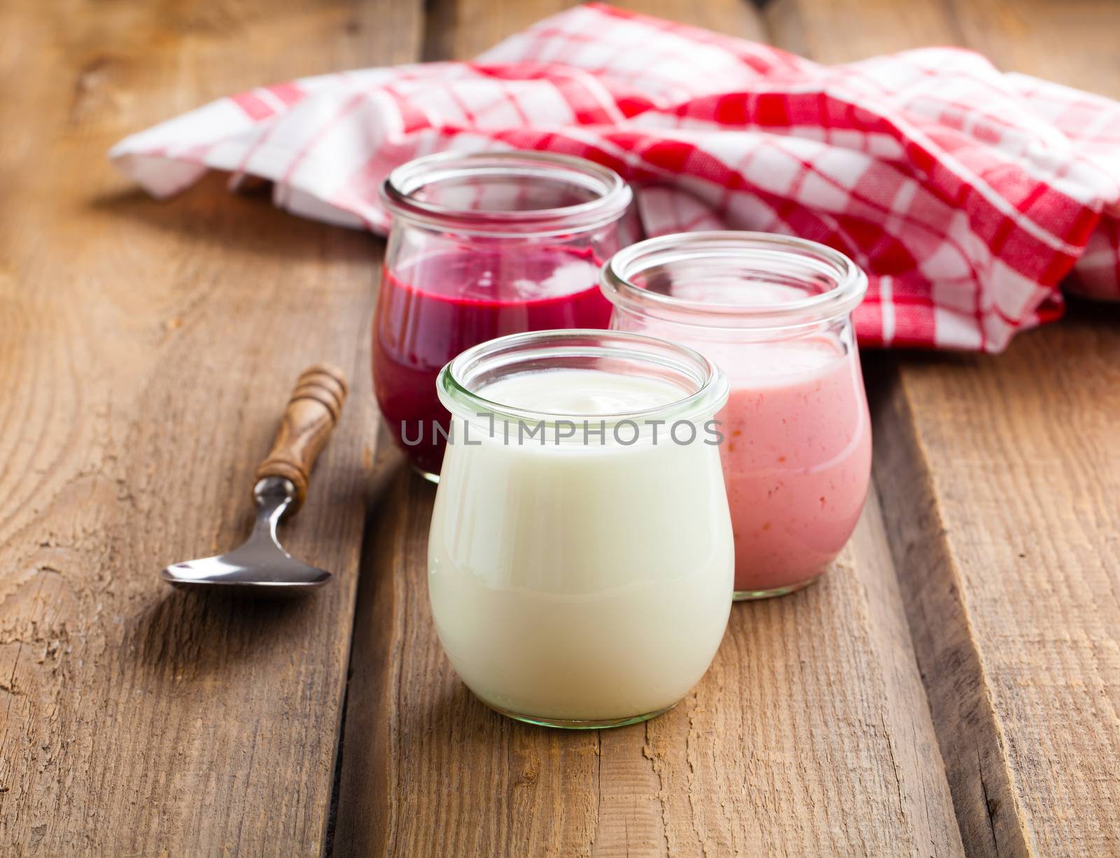 Healthy yougurt in a glass jars on wooden background by motorolka