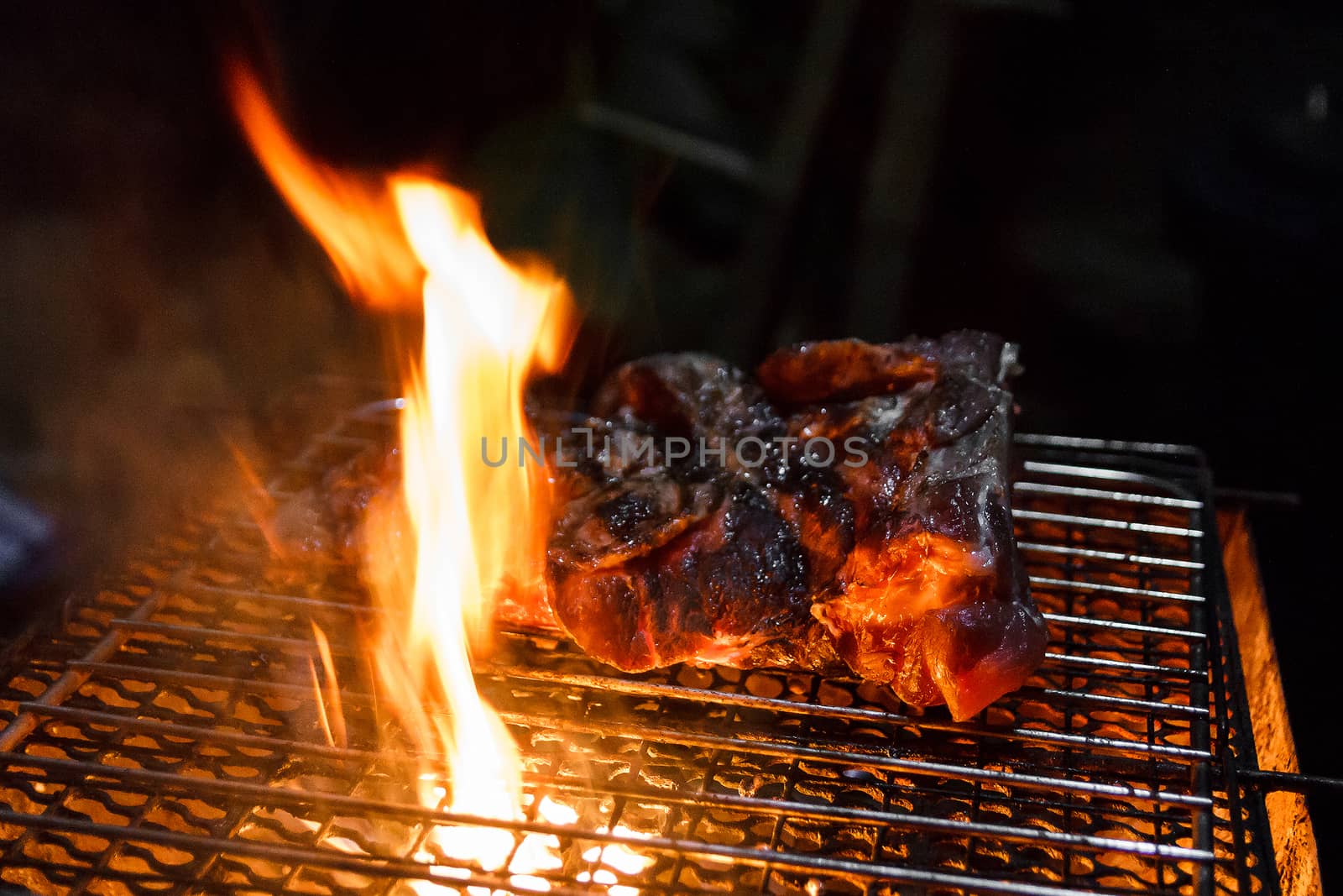 Beef on barbecue stove with flame.