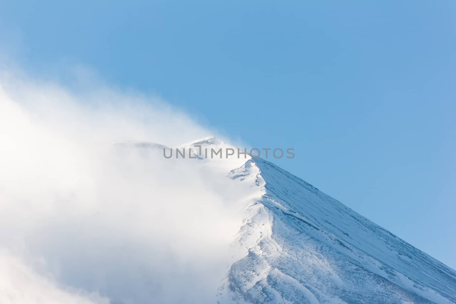 Peak of Fuji mountain with snow and cloud.