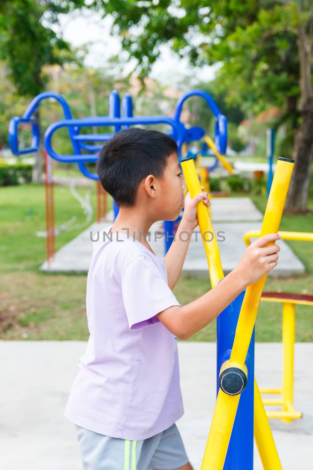 Thai boy working out with Elliptical.