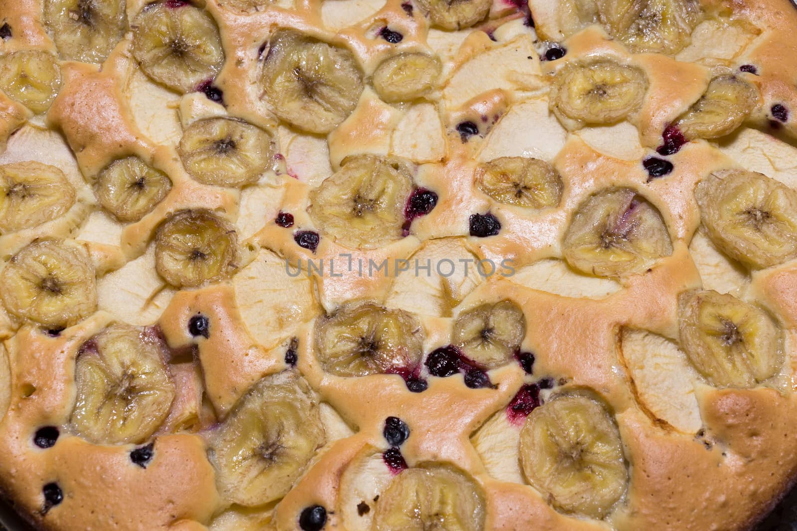 The photo depicts a cake with fruit and berries