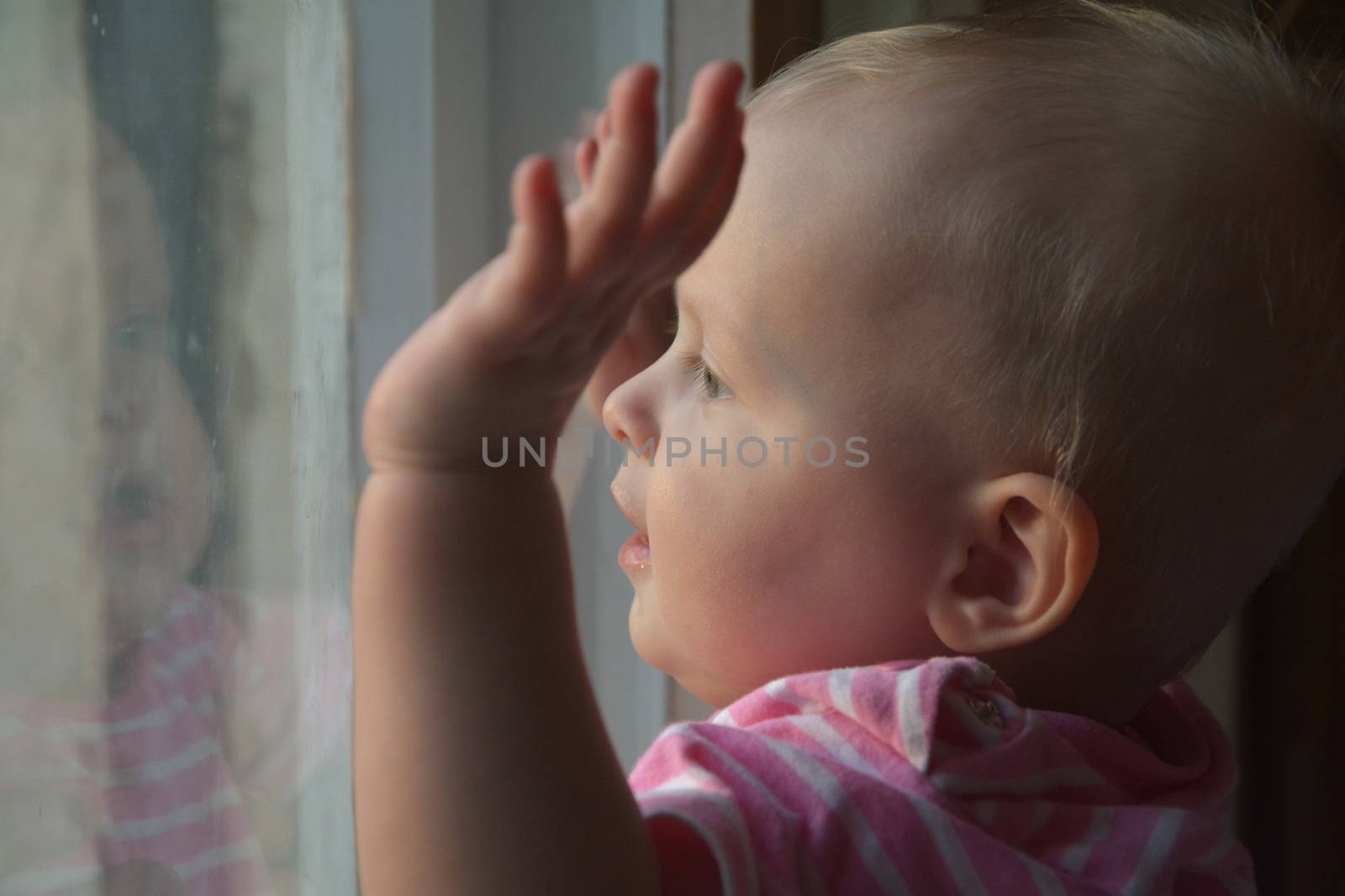 Cute baby at home in  room stands near window