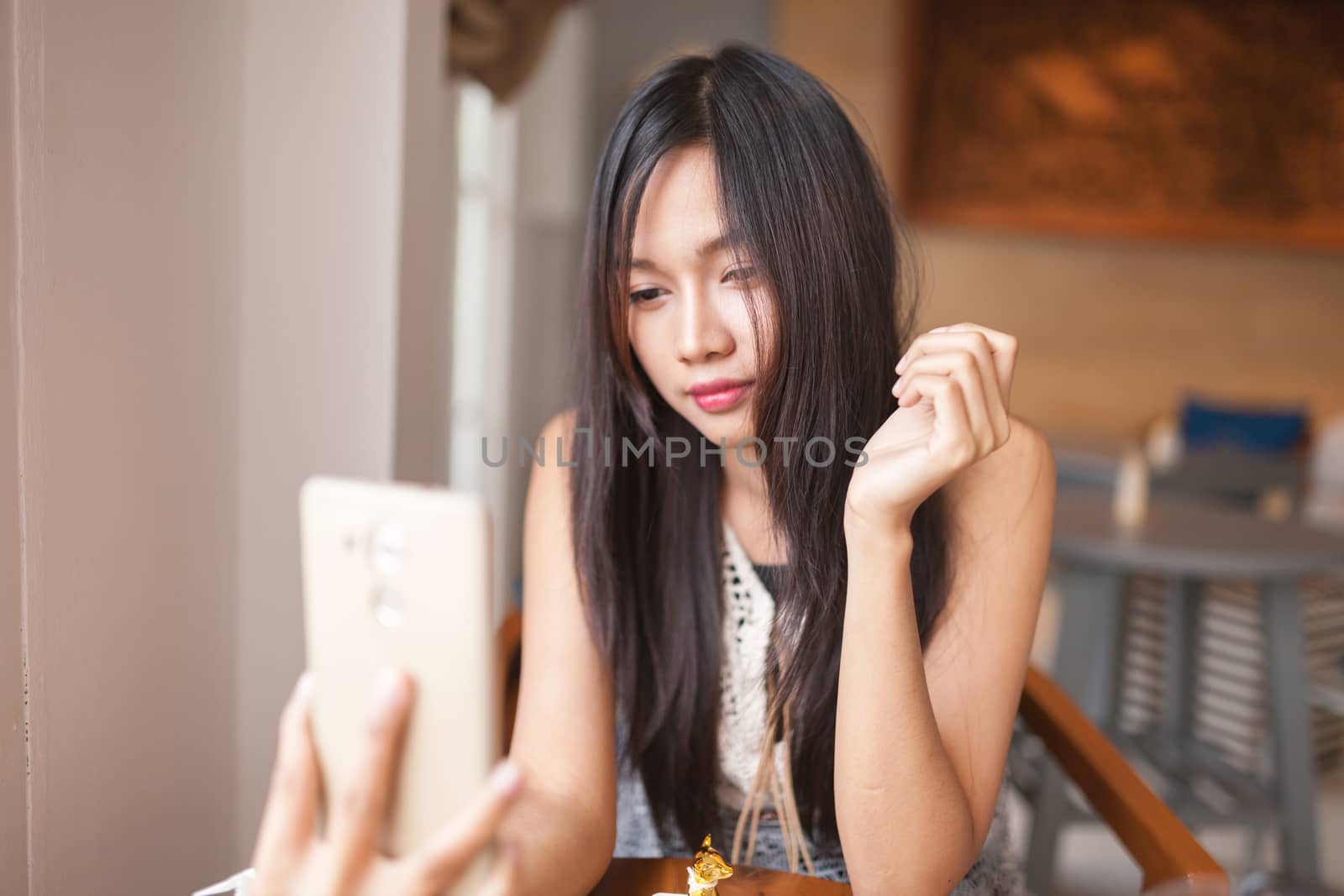 Home, technology and lifestyle concept - A women using smartphone for capture selfie .