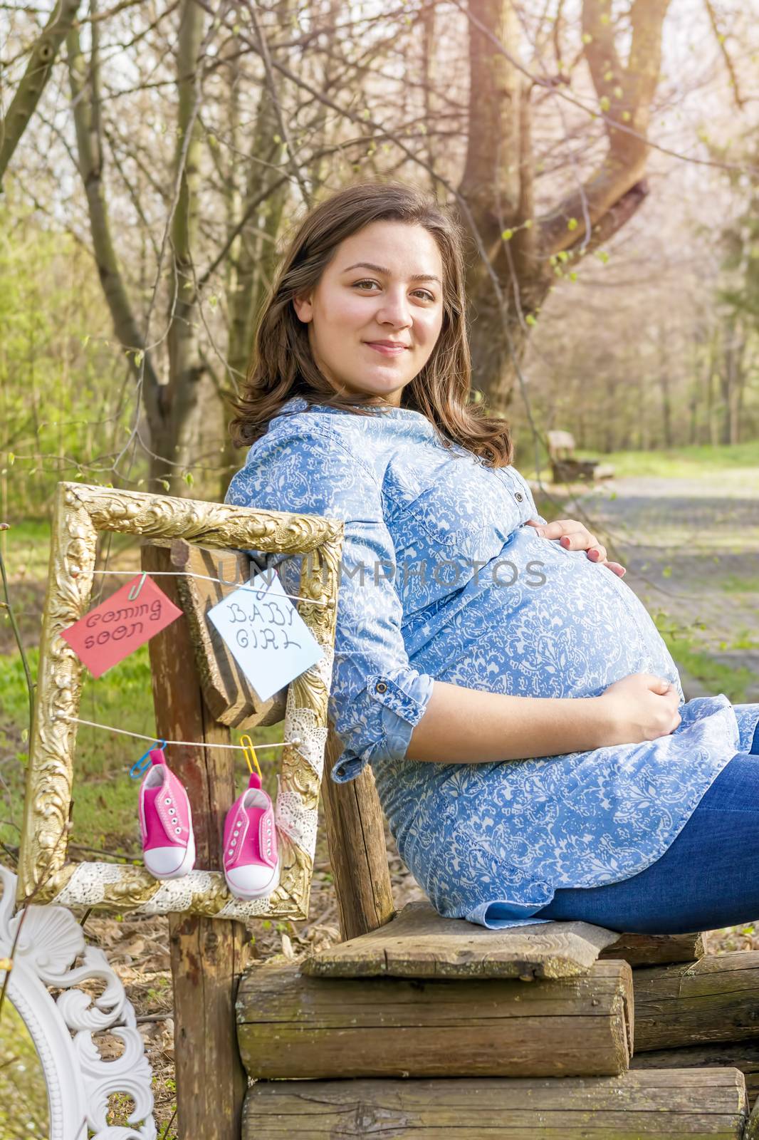 beautiful pregnant woman outdoor in the park on banch by manaemedia