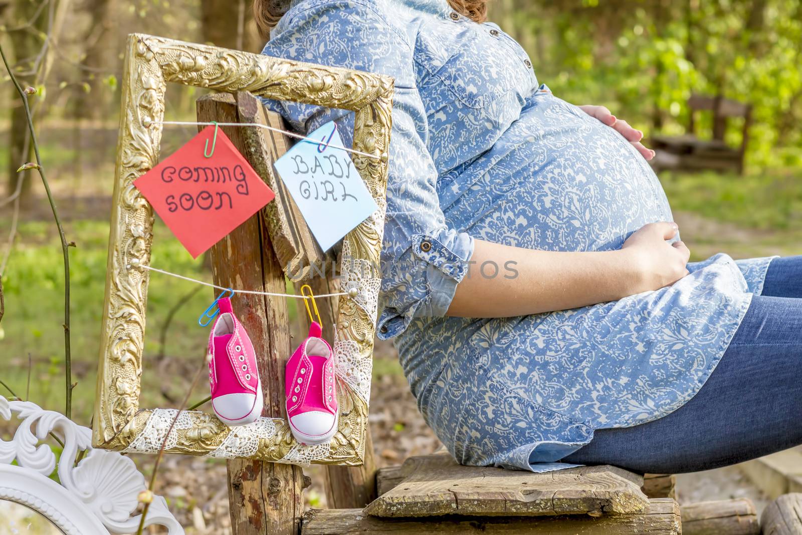 pregnant woman outdoor in the park on banch by manaemedia