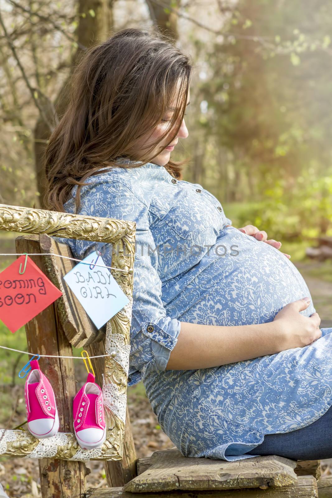 beautiful pregnant woman outdoor in the park on banch by manaemedia