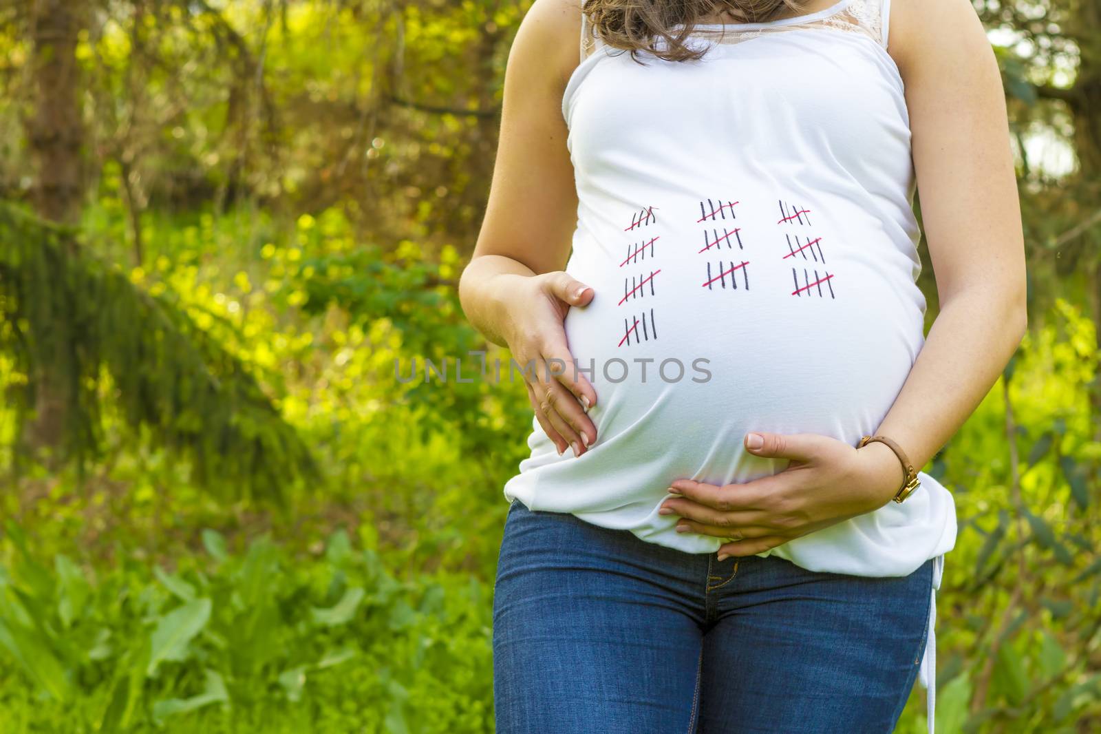 Pregnant young woman outdoors in warm summer day by manaemedia