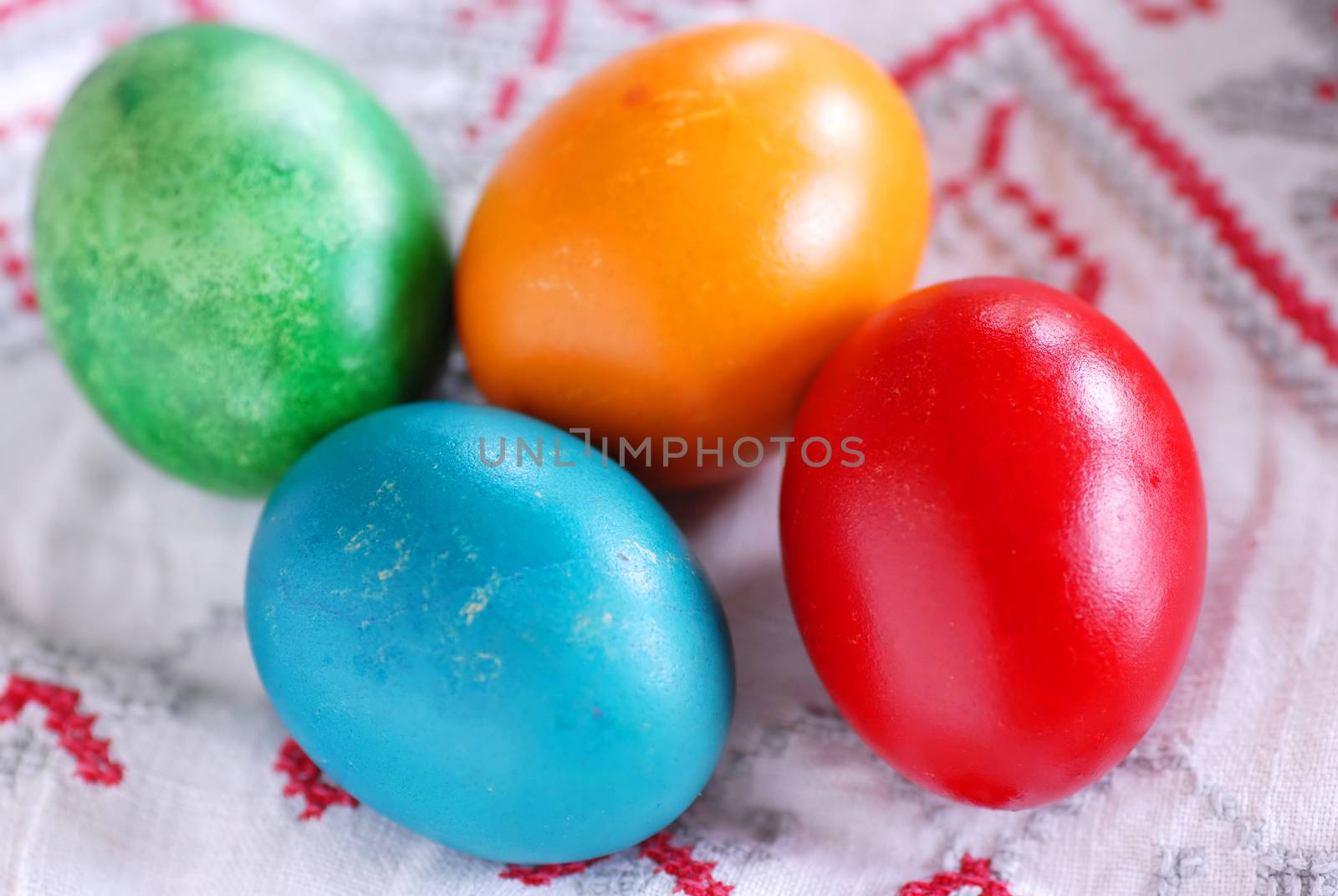 four colorful ester eggs on linen tablecloth