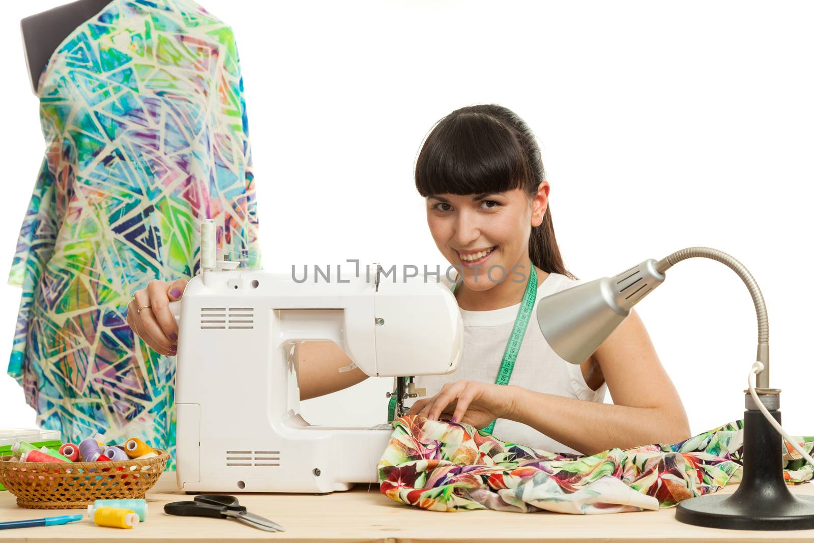 the seamstress sews a product on a table on the sewing machine
