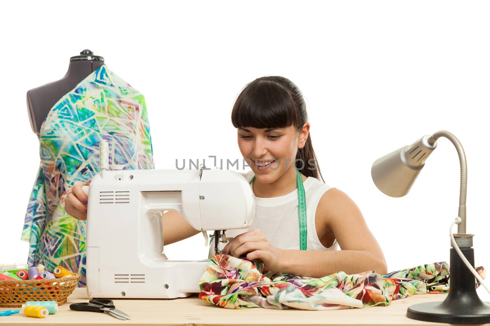 the seamstress sews a product on a table on the sewing machine