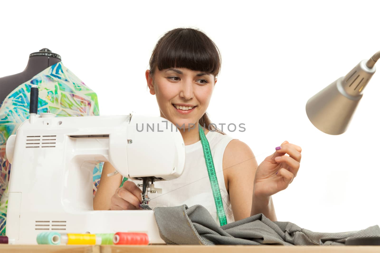 the seamstress sews a product on a table on the sewing machine