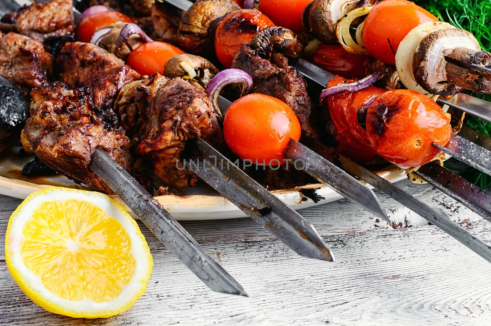few of the skewers with cooked meats and fried tomatoes