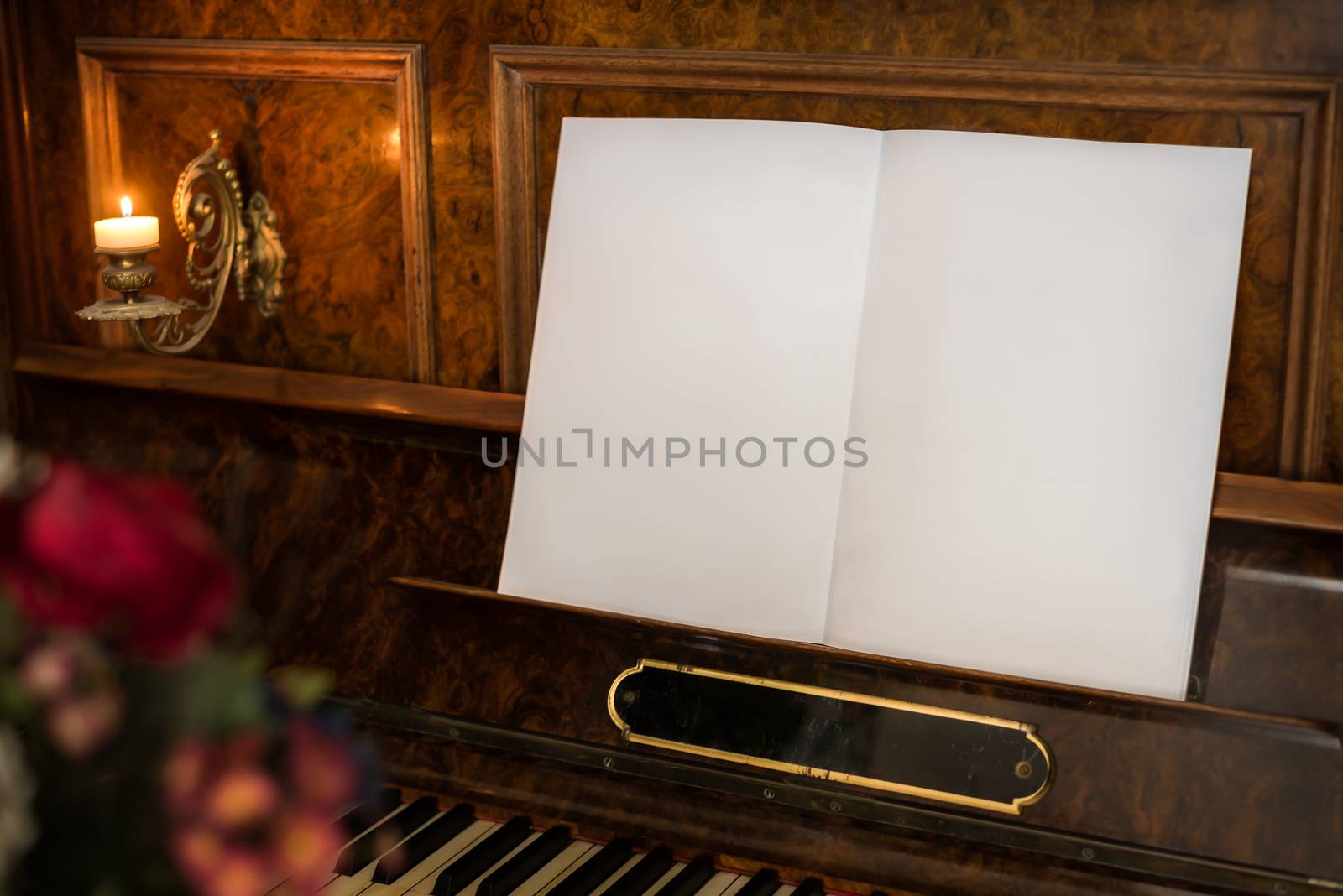 Open Blank Book with Copy Space on Beautiful Old Piano with Flowers in Foreground