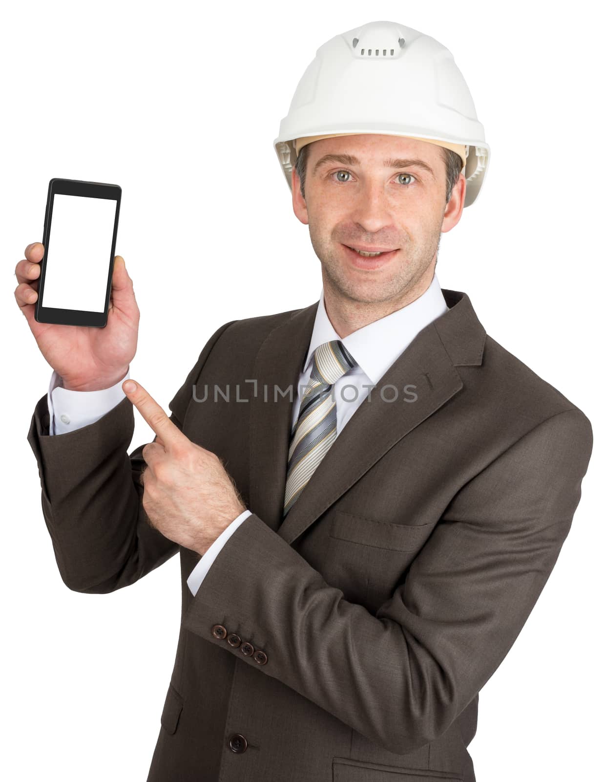Smiling businessman in helmet showing mobile with blank screen isolated on white background