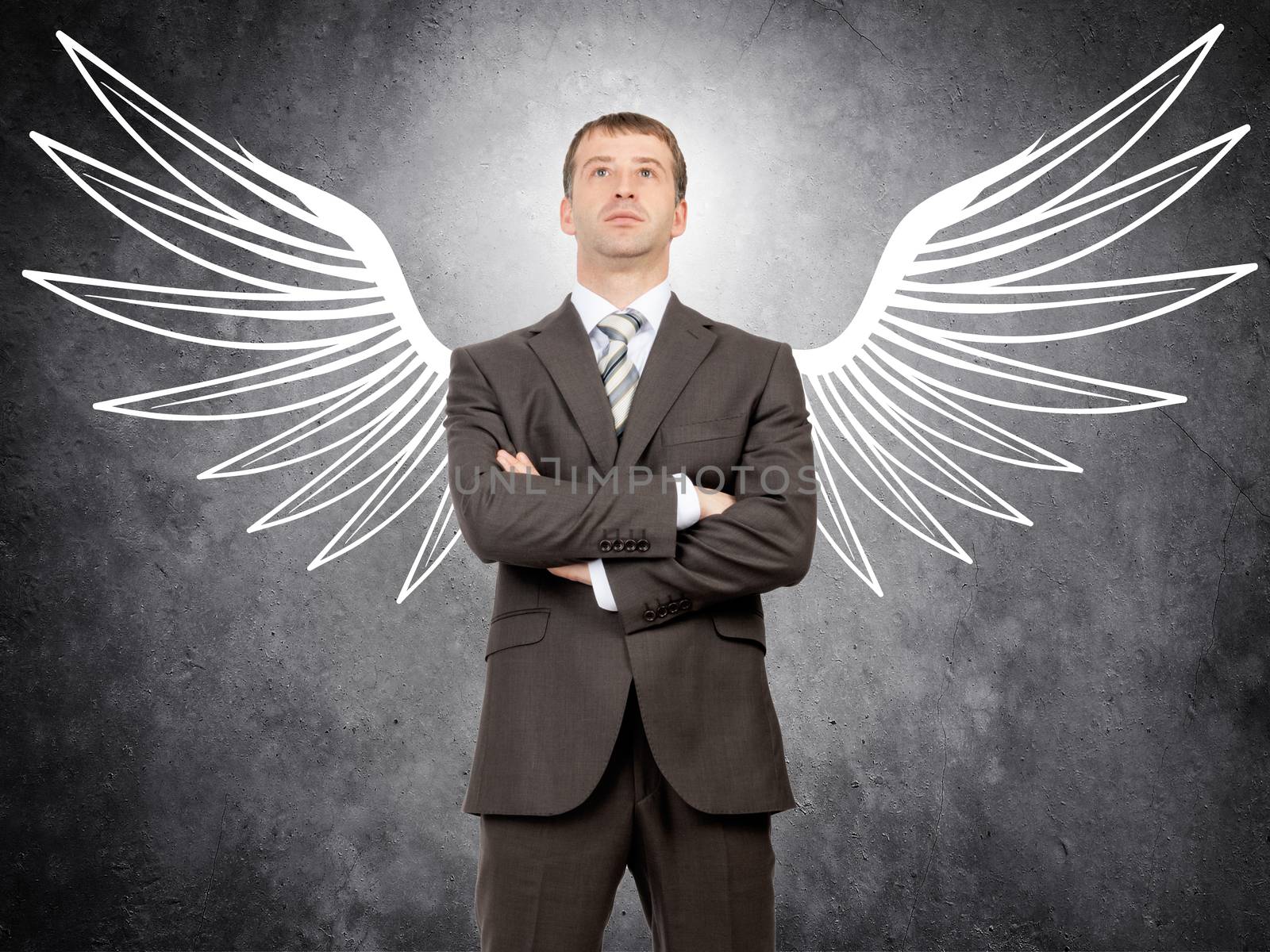 Businessman with drawn angel wings looking at camera