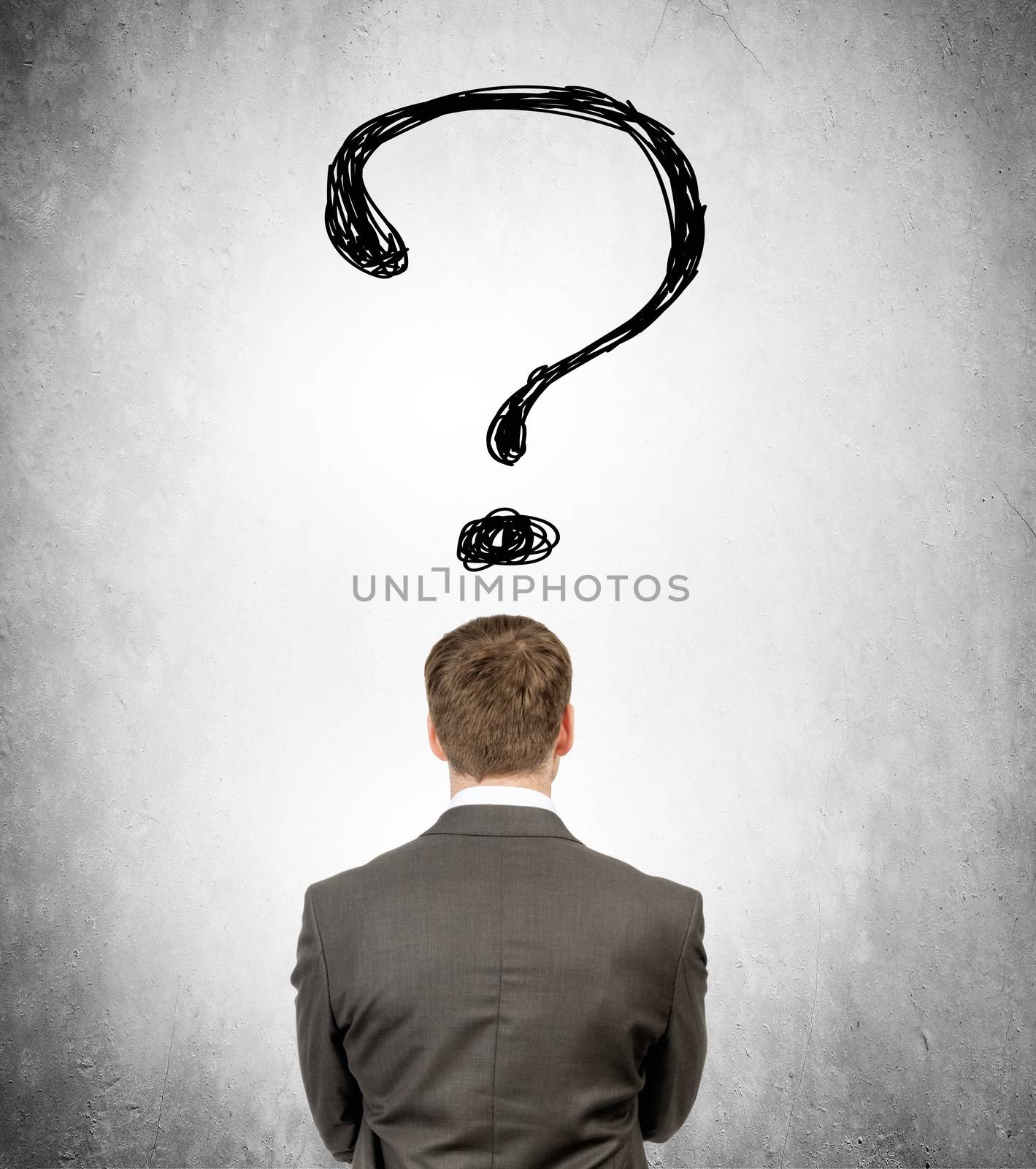 Rear view of businessman with big question mark on grey wall background