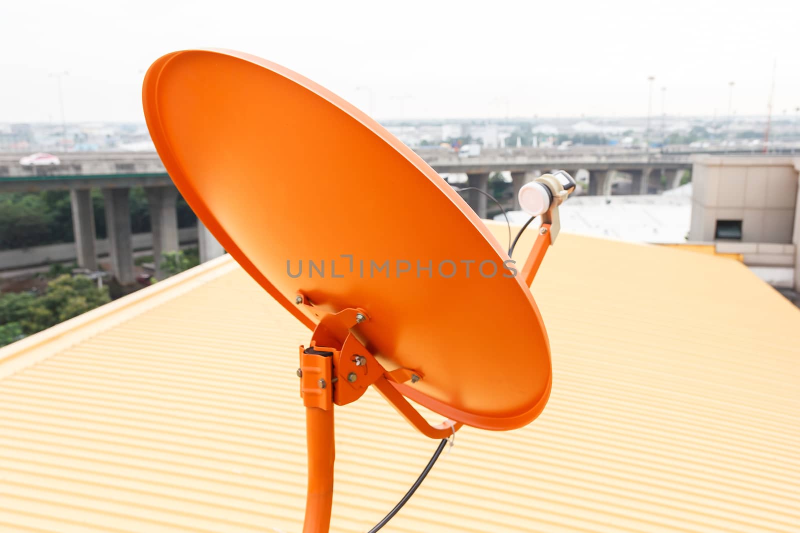 Orange satellite dish with yellow roof in background.