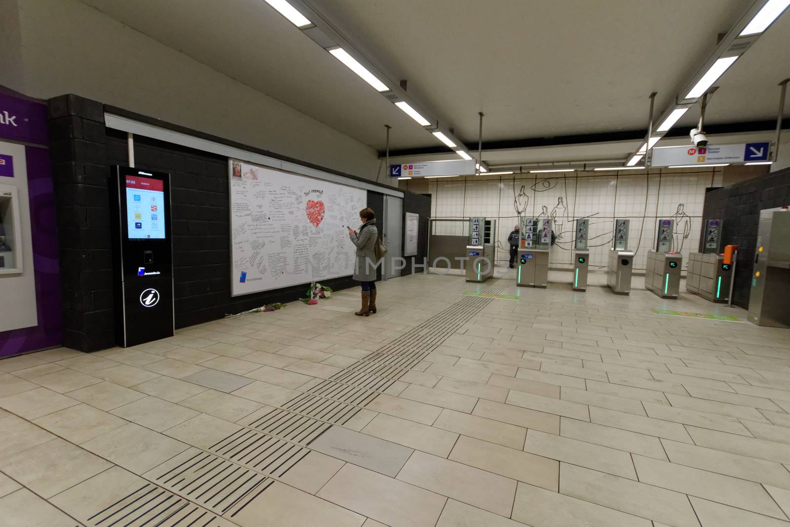 BELGIUM, Brussels : A woman reads messages on a commemorative wall at the Maelbeek - Maalbeek metro station on its re-opening day on April 25, 2016 in Brussels, after being closed since the 22 March attacks in the Belgian capital.Maelbeek - Maalbeek metro station was hit by one of the three Islamic State suicide bombers who struck Brussels airport and metro on March 22, killing 32 people and injuring hundreds.