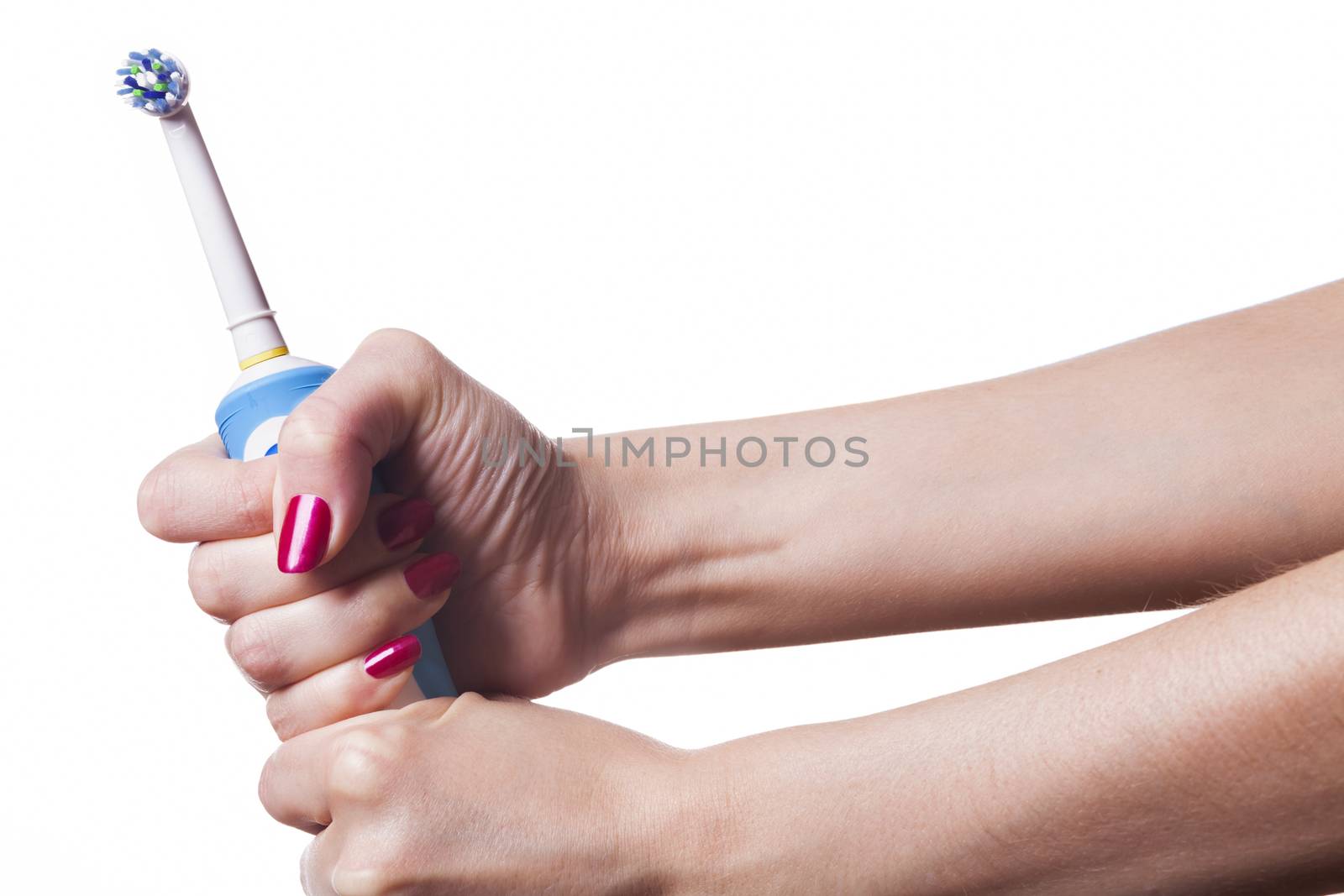 Hand holds electric toothbrush against white by juniart