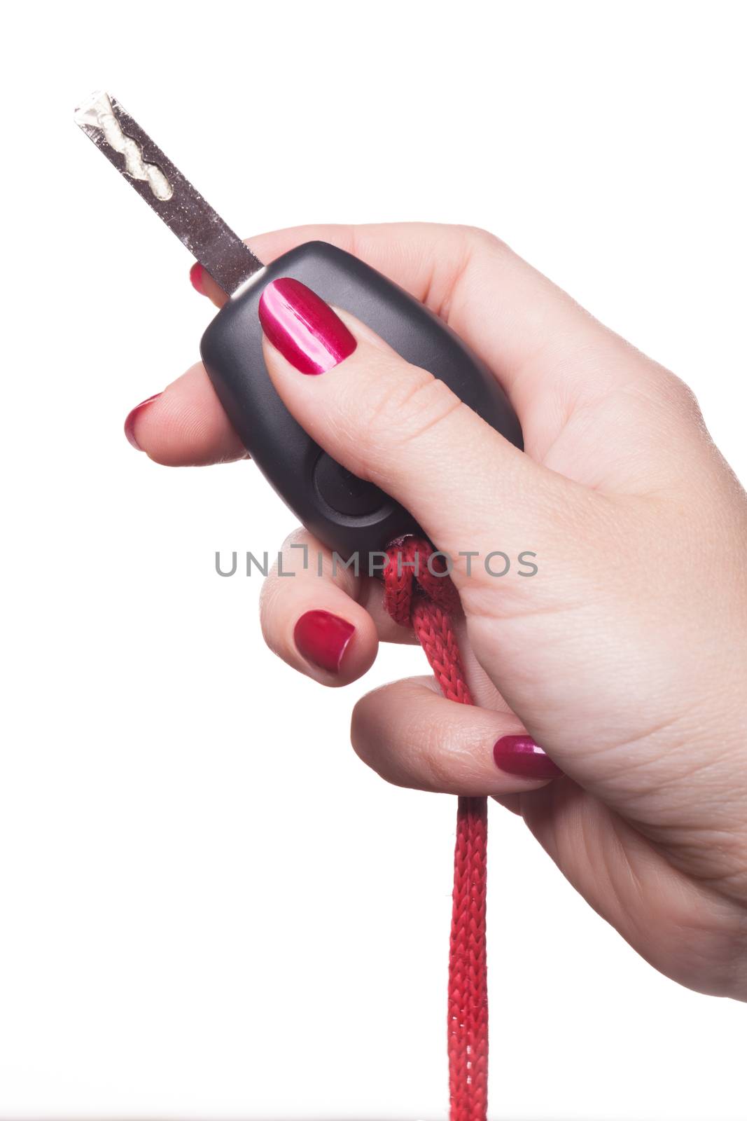 Close up of manicured hand with red nail polish holding black car key on white background