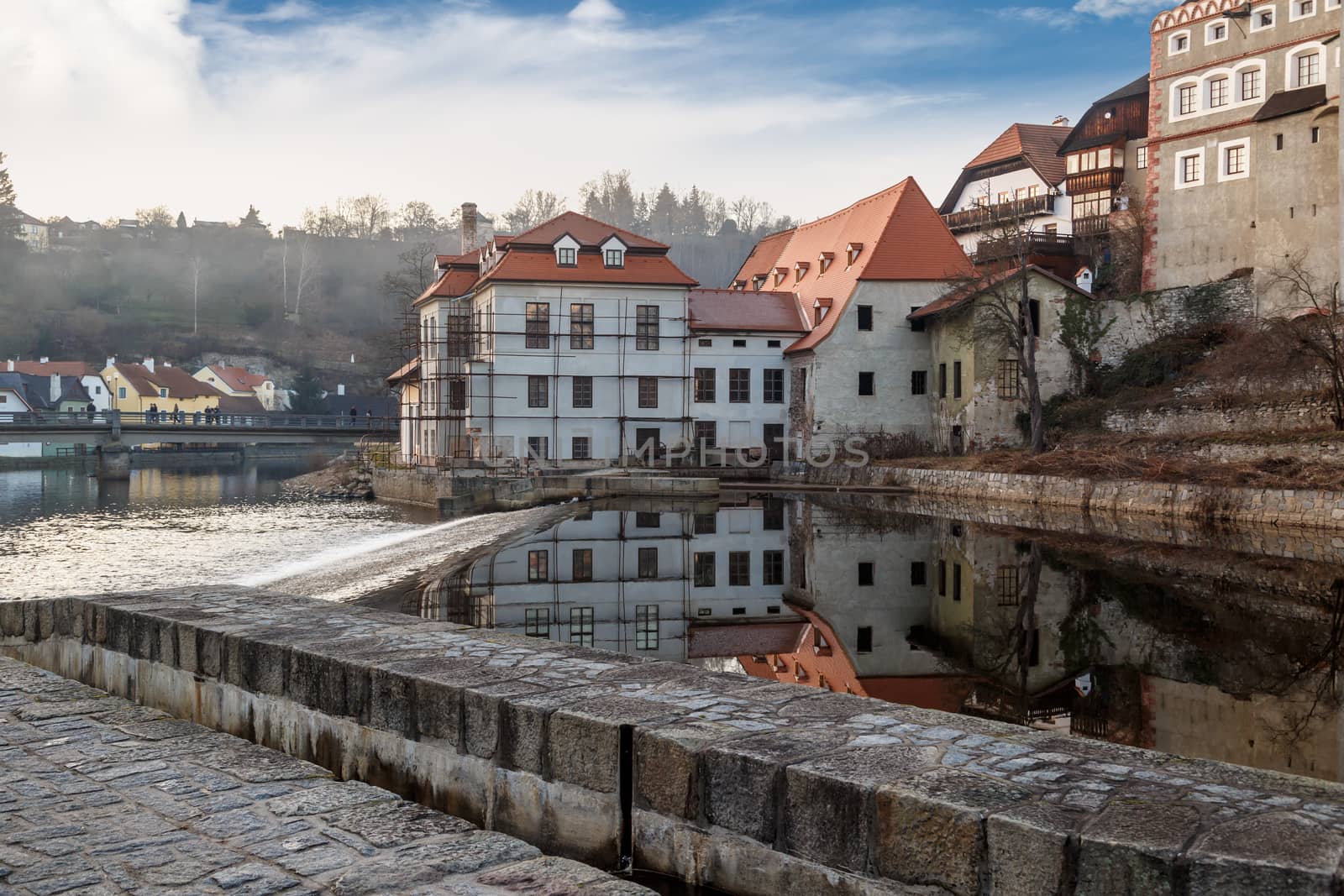 General Cesky Krumlov view with historical small houses along the river, on cloudy blue sky background.
