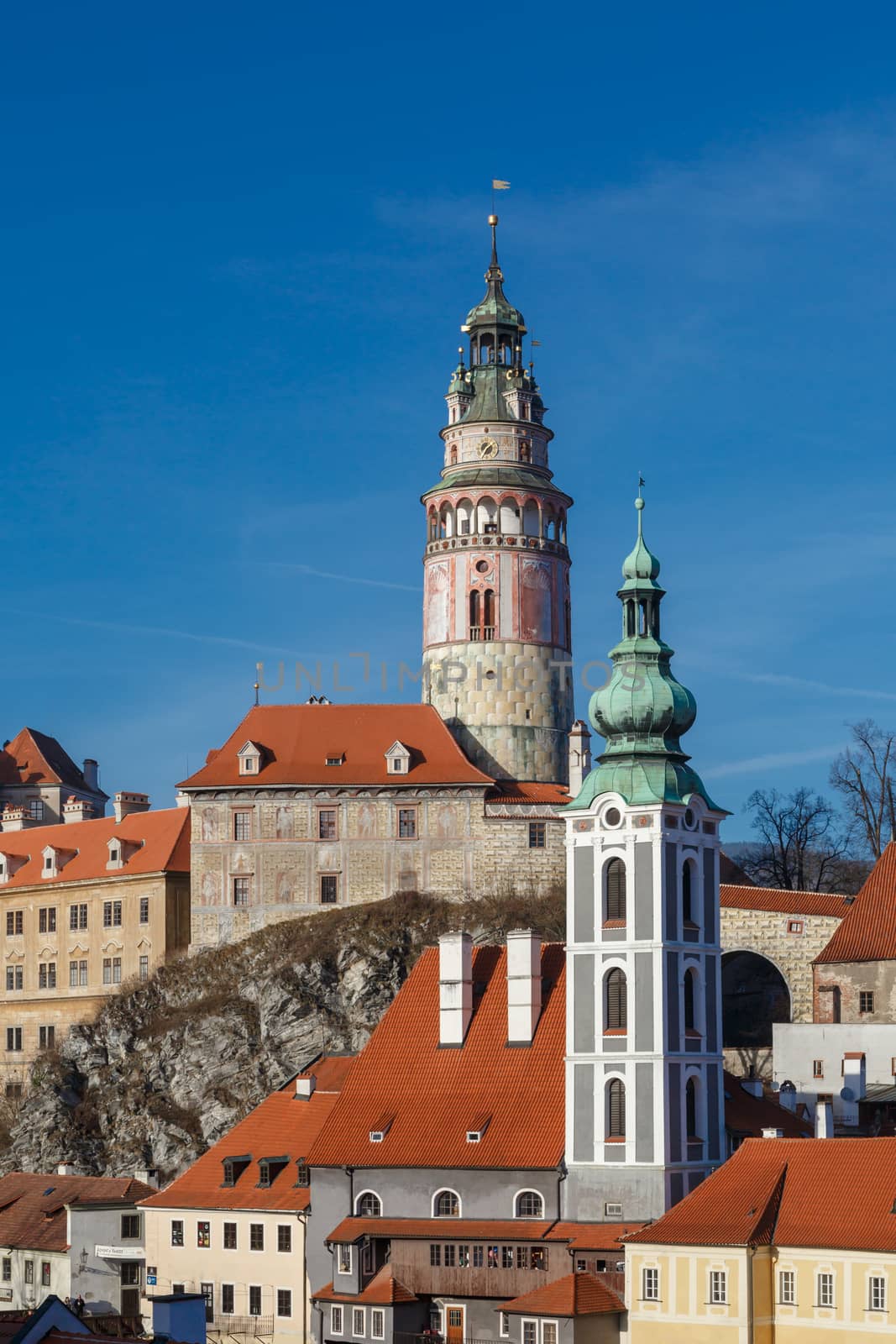 General Cesky Krumlov view with gothic towers and historical small houses around,  on bright sky background.