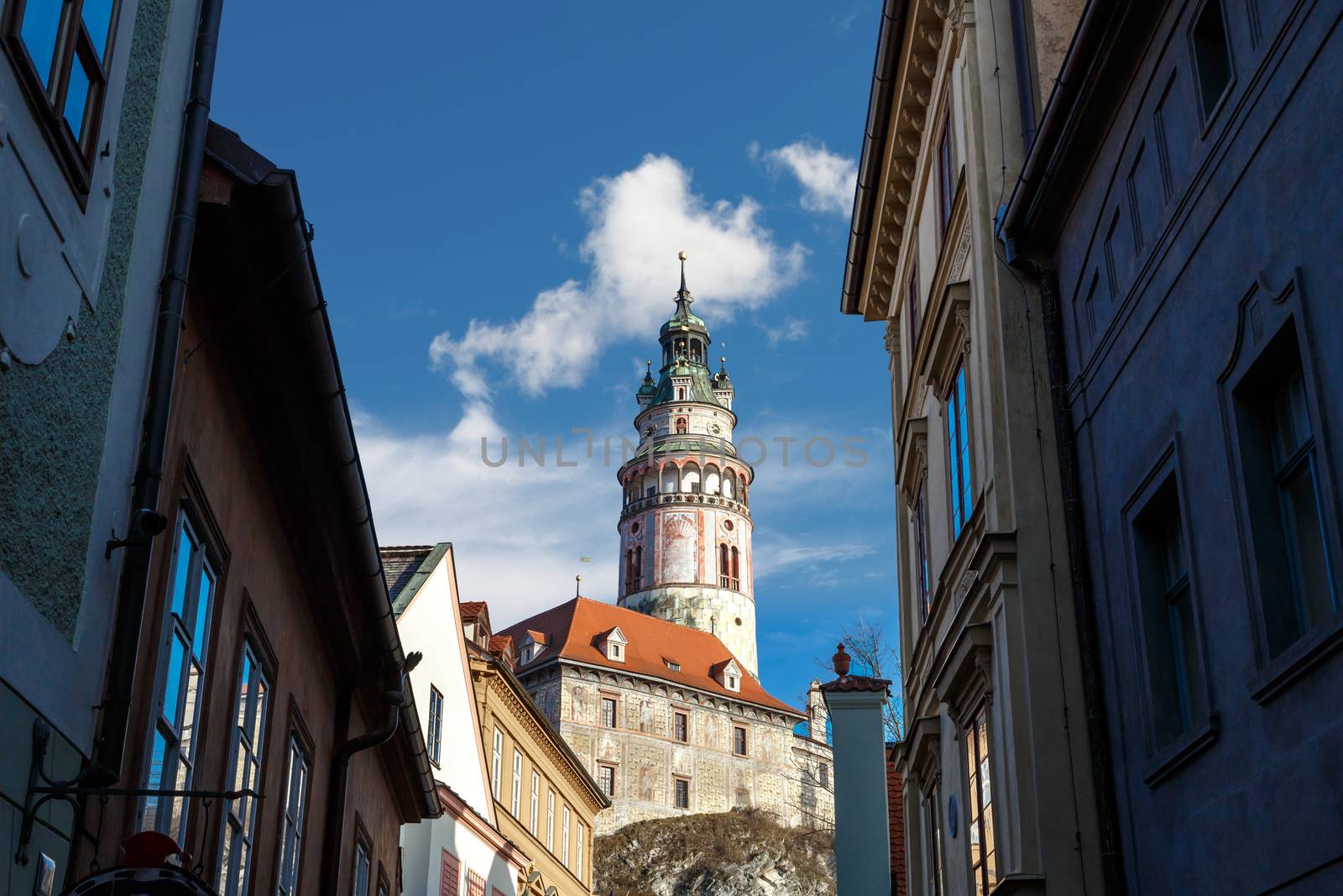 General view of Little Castle Tower in Cesky Krumlov, colorful historical tower on cloudy blue sky background.