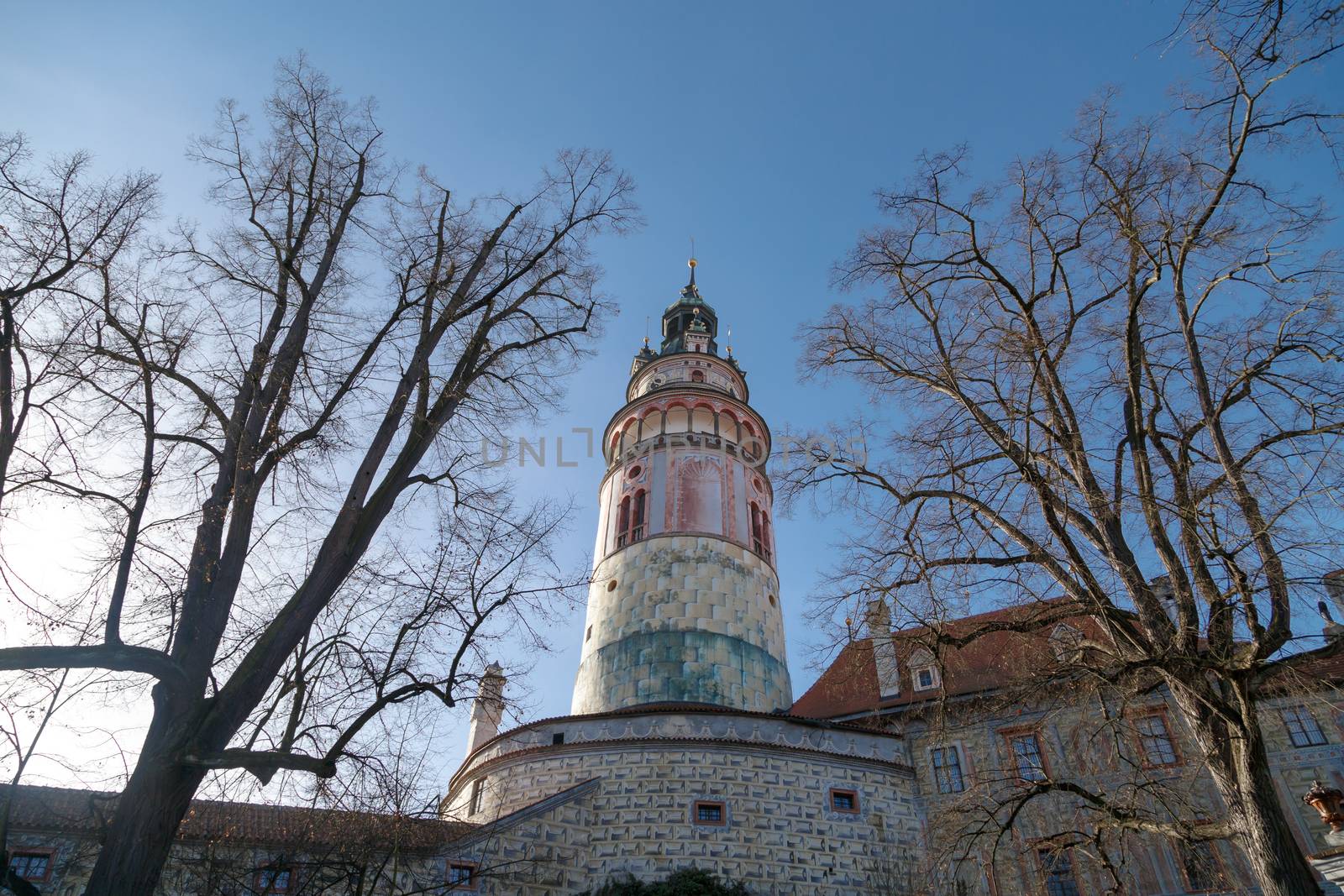 General view of Little Castle Tower in Cesky Krumlov, colorful historical tower on bright blue sky background.