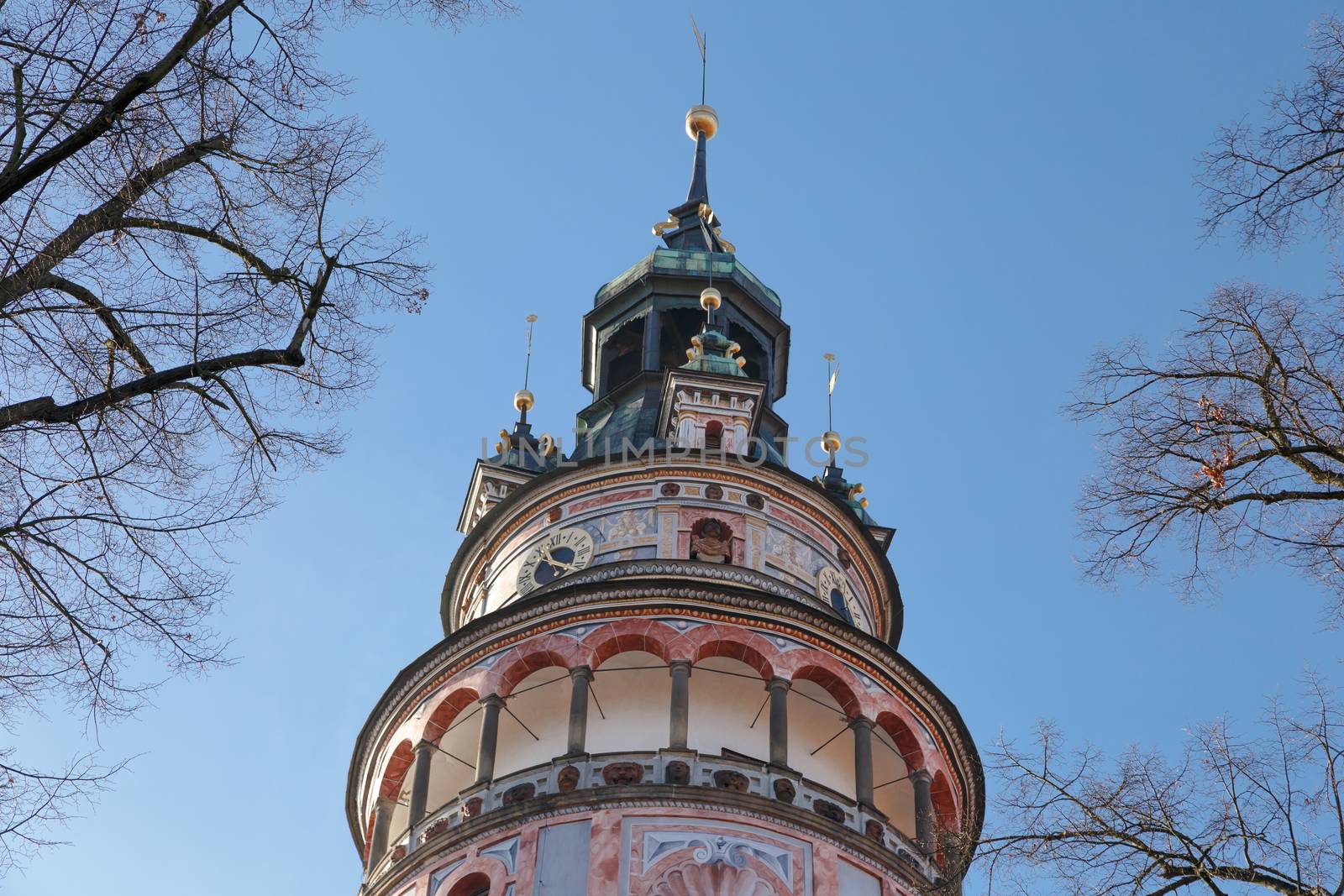 Detailed view of Little Castle Tower in Cesky Krumlov, colorful historical tower on bright blue sky background.