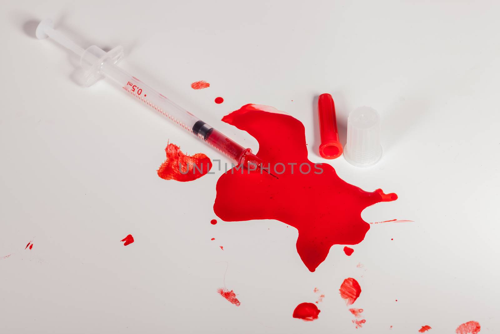 High Angle View of Syringe Needle Squirting Red Liquid or Blood onto White Background in Studio Still Life - Concept Image