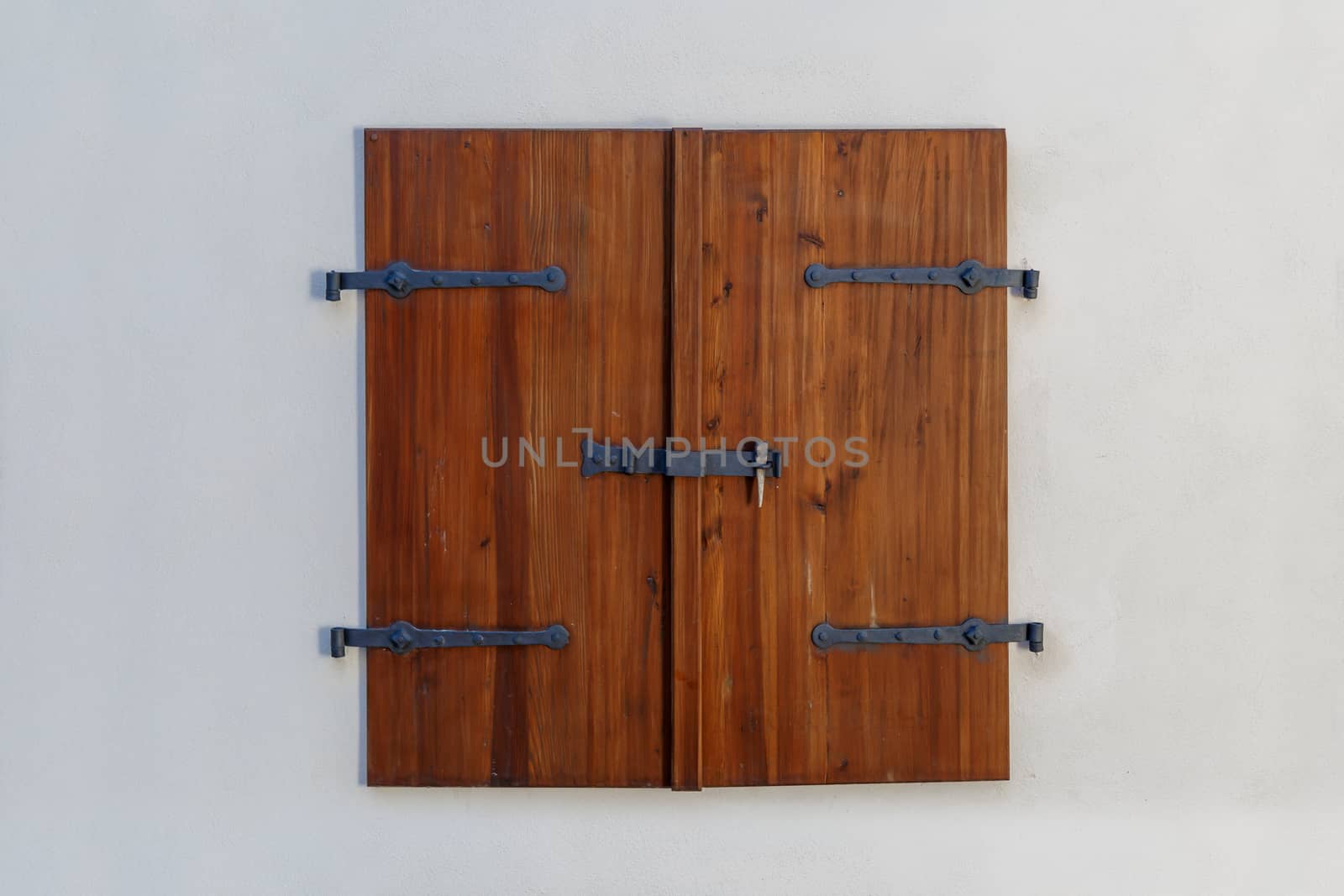 Close up detailed view of old wooden door on a white wall.