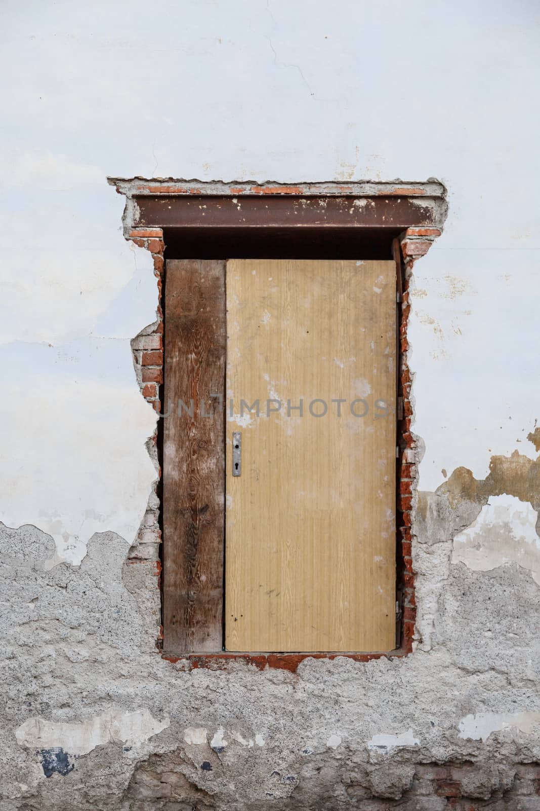 Close up detailed view of old wooden door on a white wall.