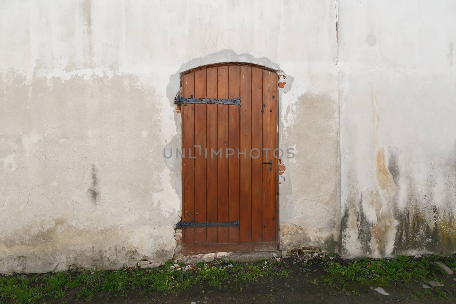 Close up detailed view of old wooden door on a white wall.