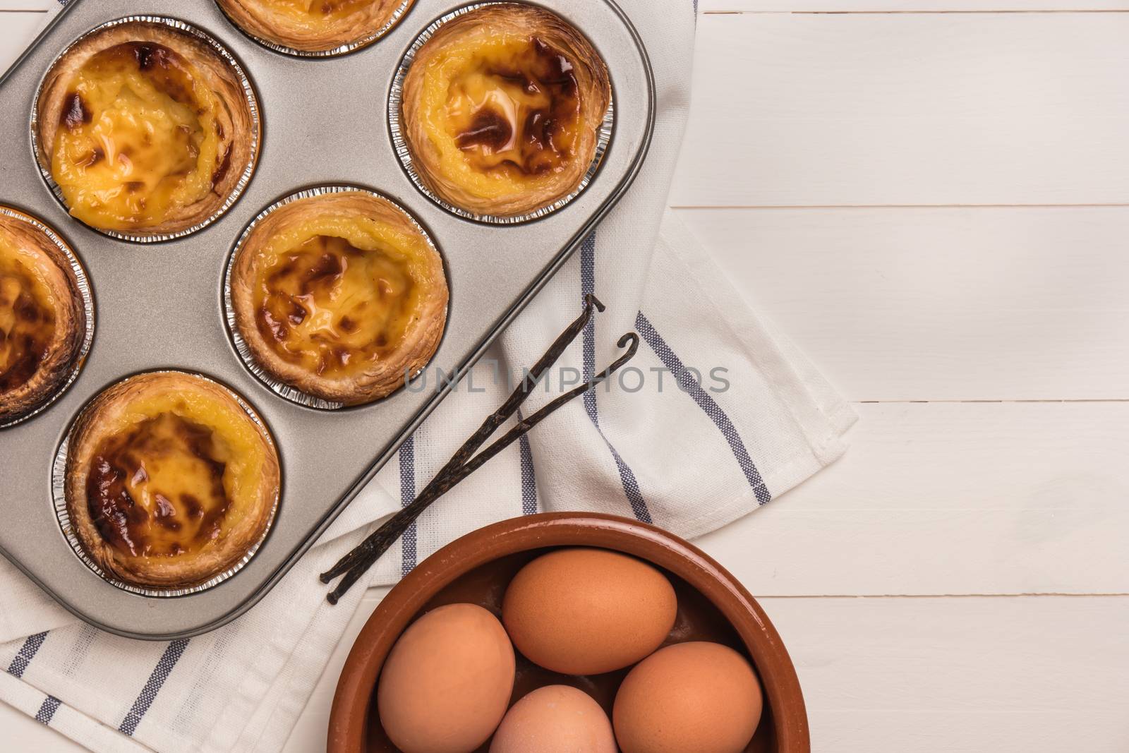 Pasteis de nata, typical Portuguese egg tart pastries from Lisbon on a set table. Top view with copy space