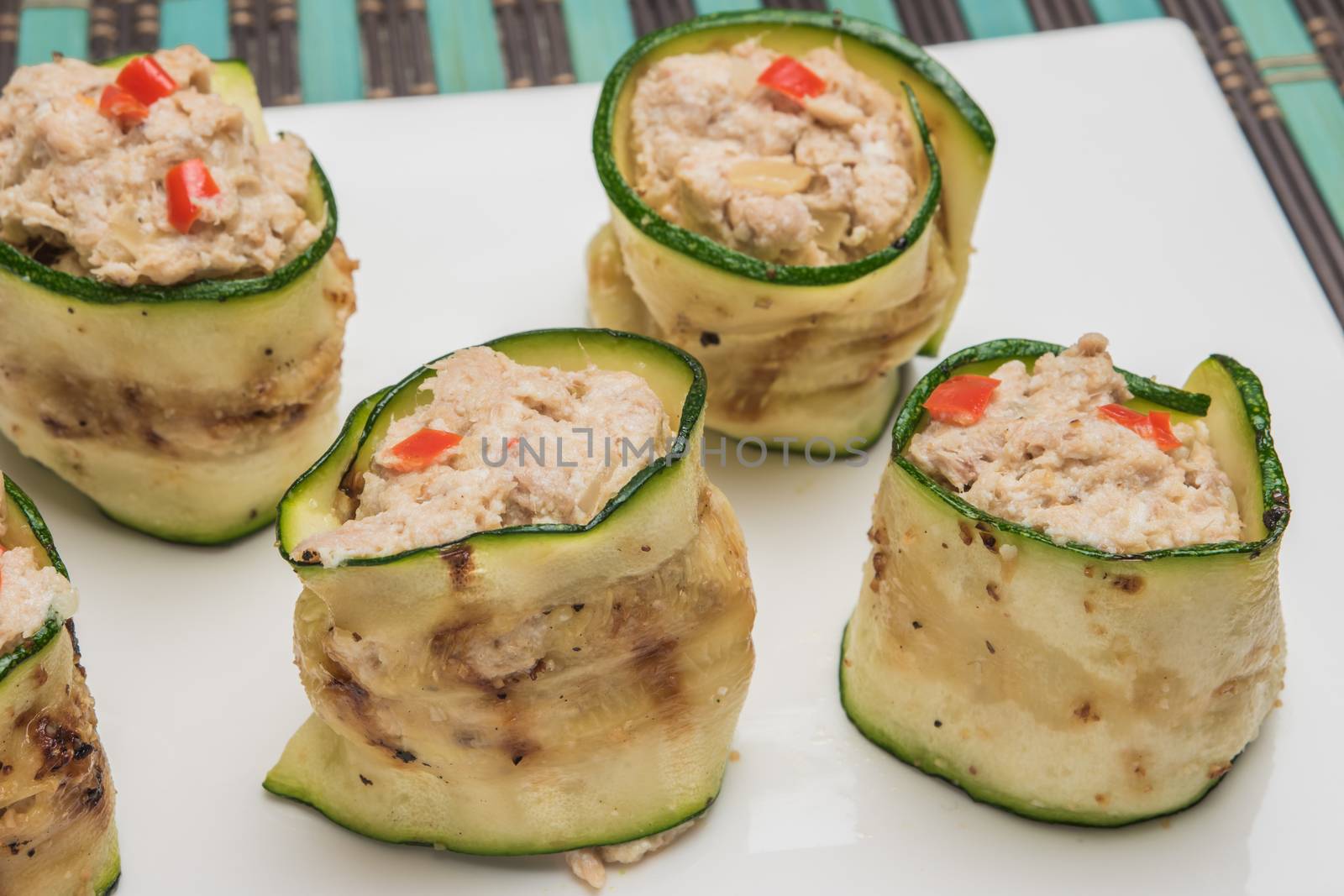 Grilled zucchini rolls with curd cheese and tuna on plate. by AnaMarques