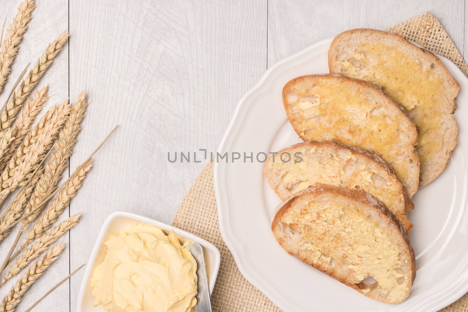 Fresh bread, wheat spike and homemade butter on wooden backgroun by AnaMarques