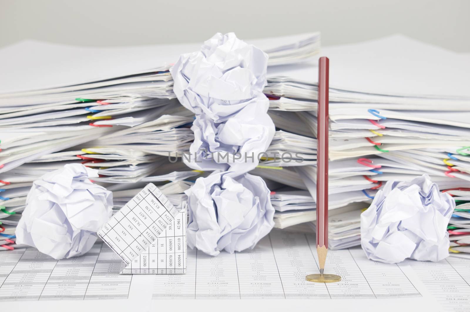 Bankruptcy of house and pencil with gold coin on finance account have blur paper ball and pile of paperwork with colorful paperclip as background.