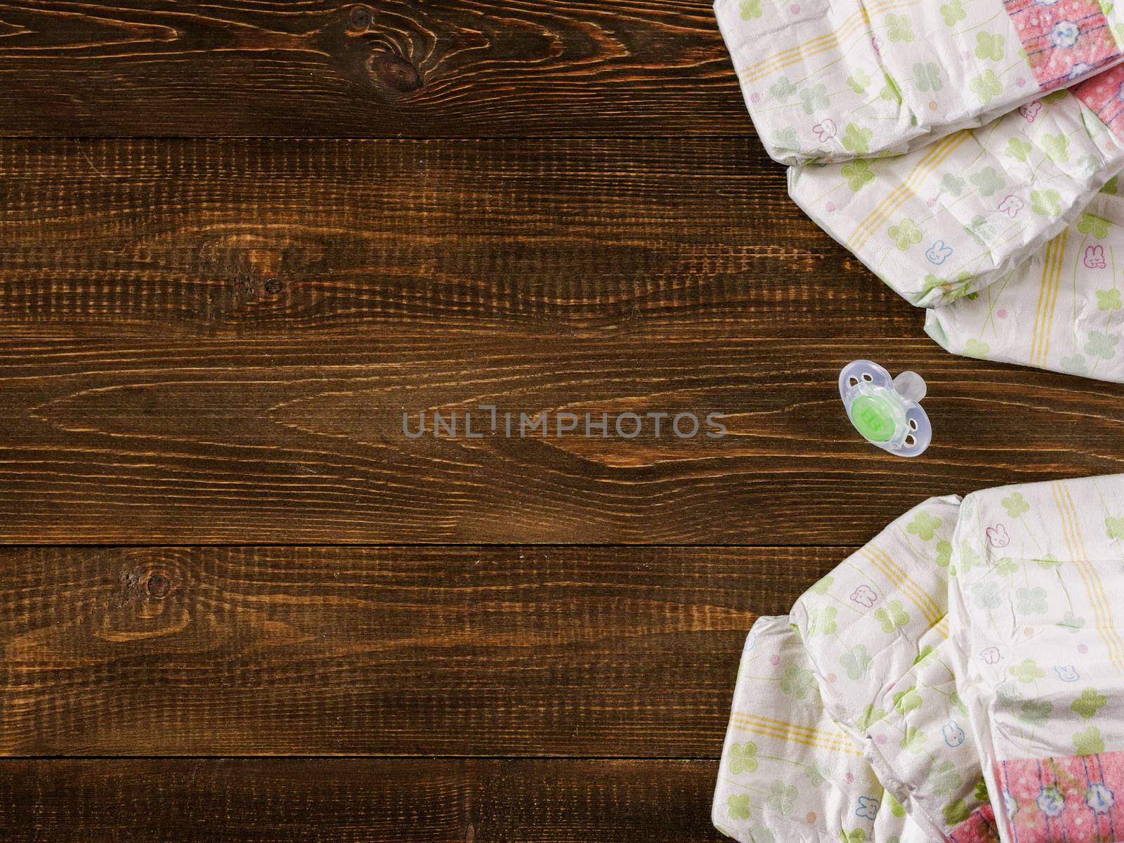 Japanese disposable diapers and dummy on dark wooden background with copy-space. Flat lay
