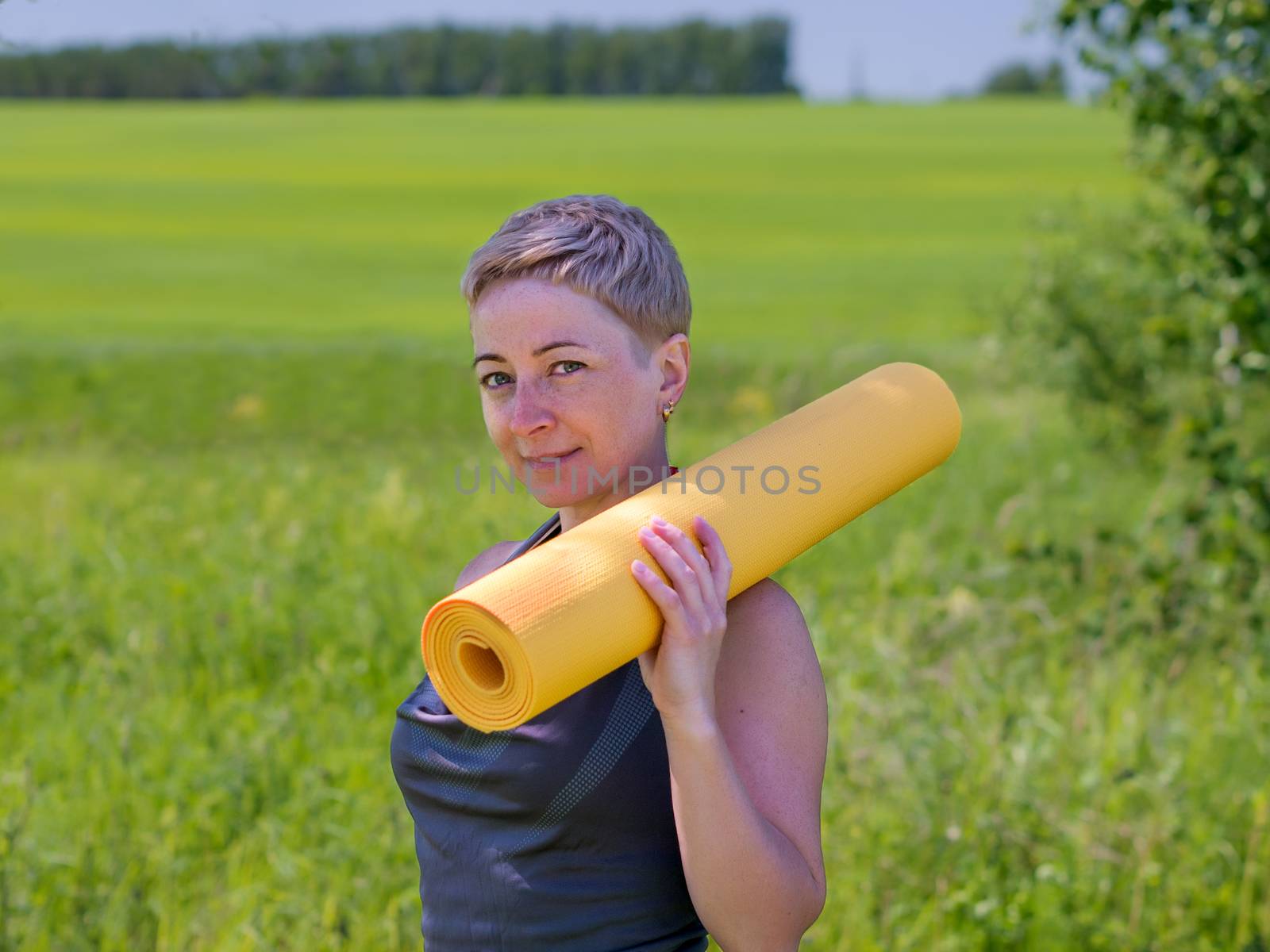 Woman Holding Rolled Up Exercise Mat by fascinadora