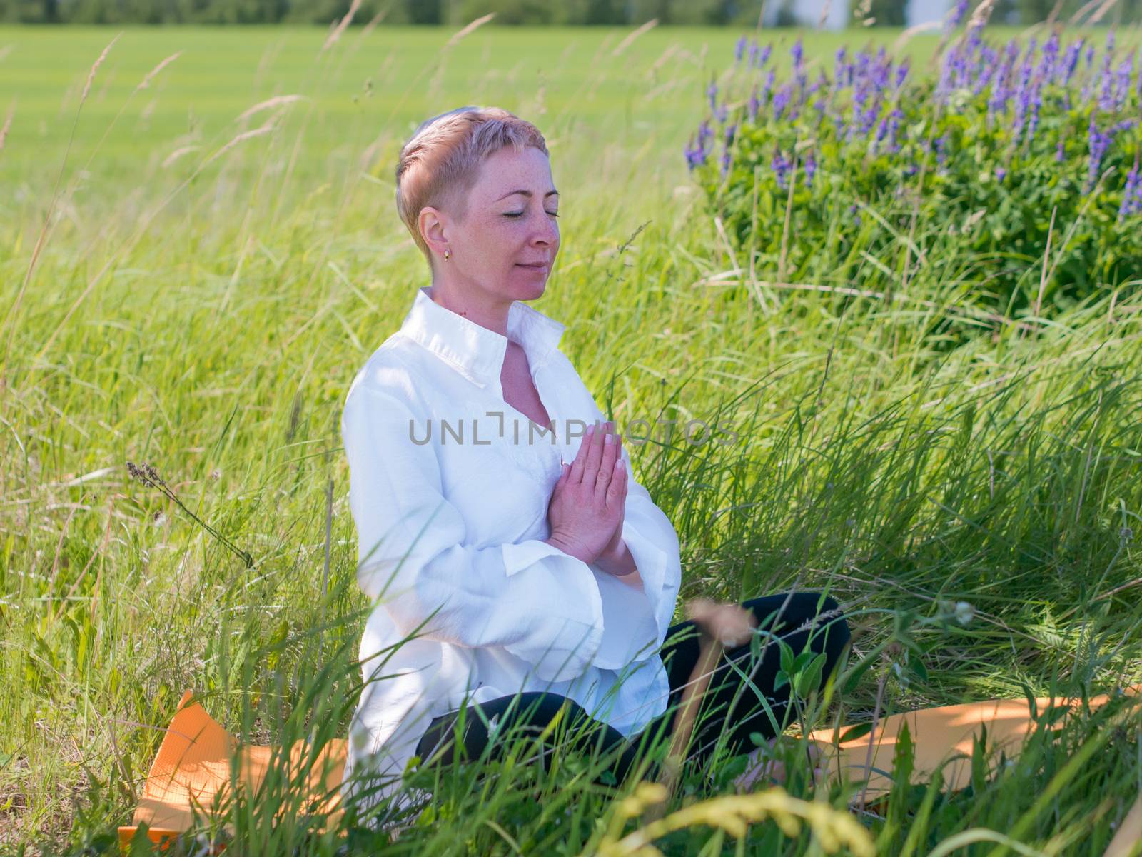 Mature woman practices yoga in nature