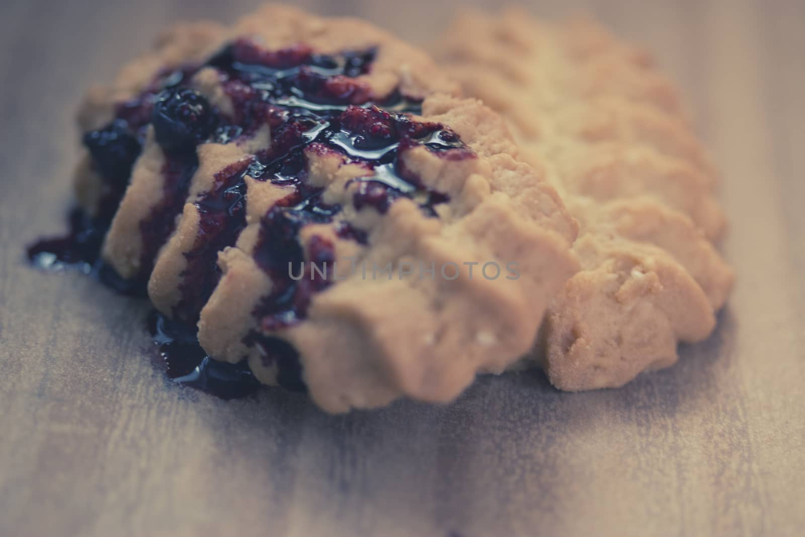 cookies with blueberry jam on wooden table