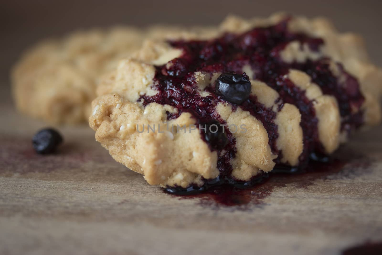 cookies with blueberry jam on wooden table
