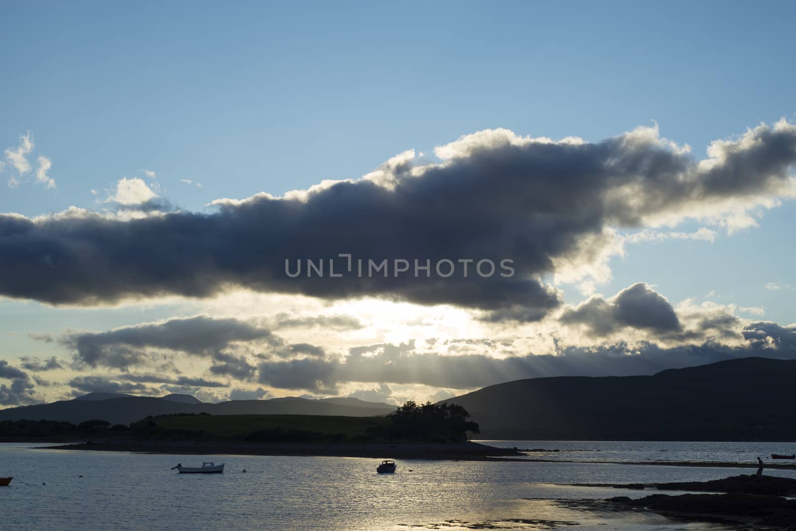 boats in a quiet bay with island near kenmare on the wild atlantic way ireland just before sunset