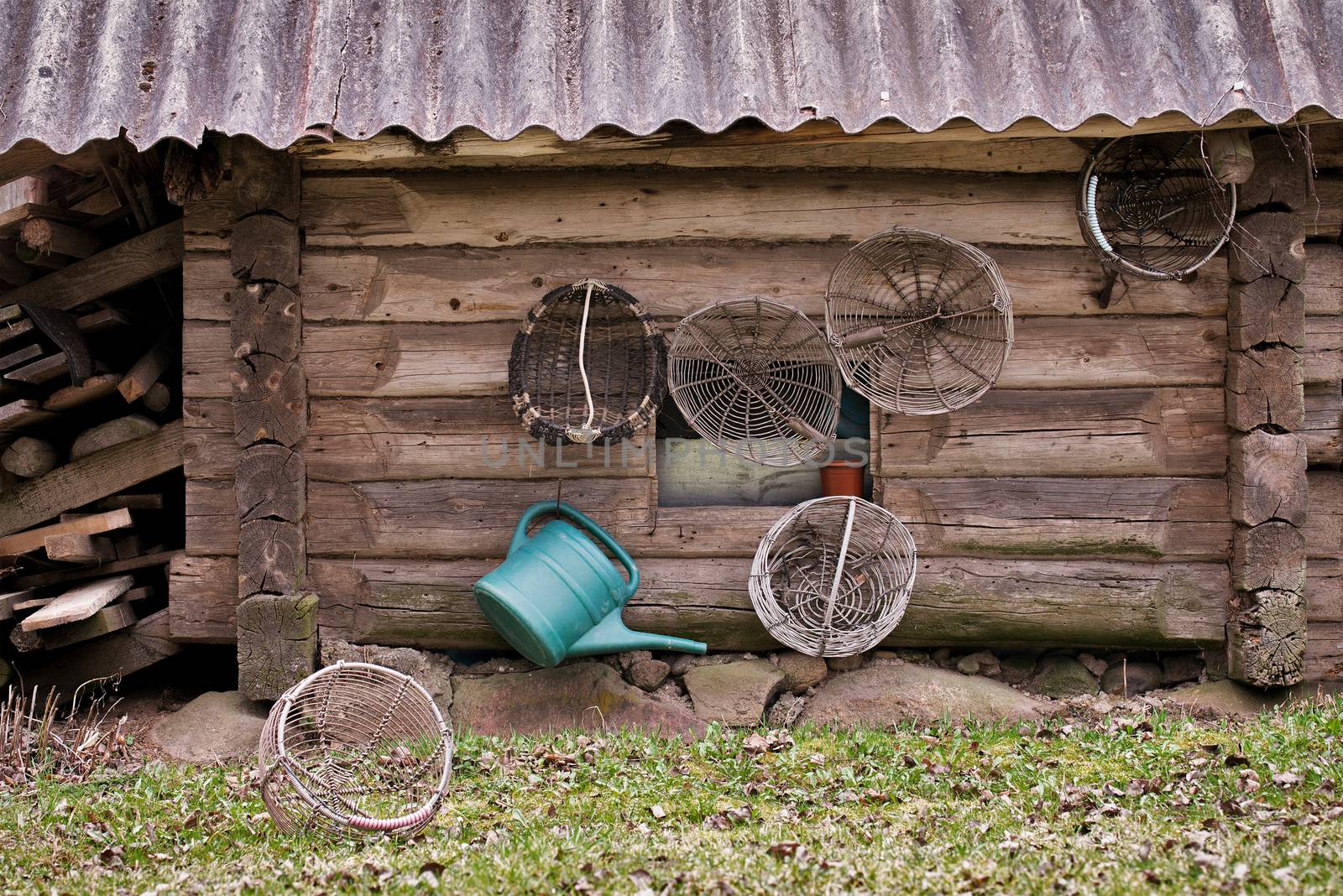 Old grunge wooden house, garden baskets and watering can hanging on the wall