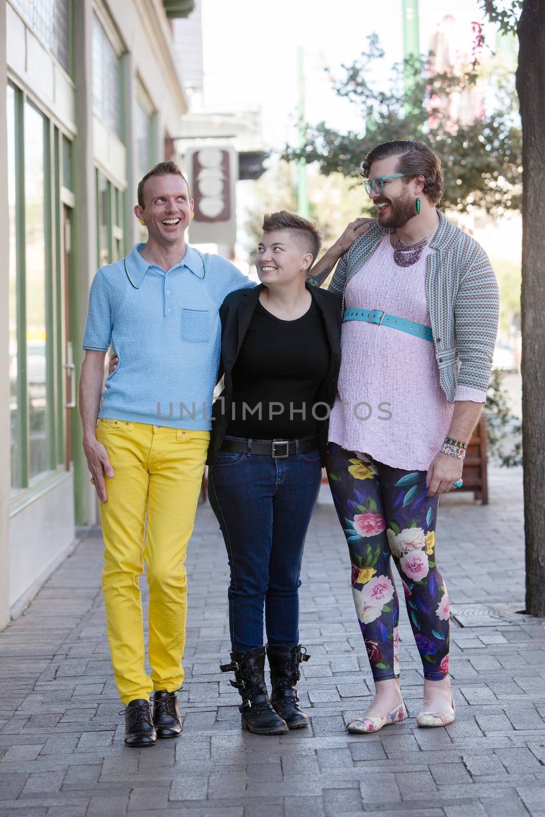 Three gender fluid friends on an urban sidewalk