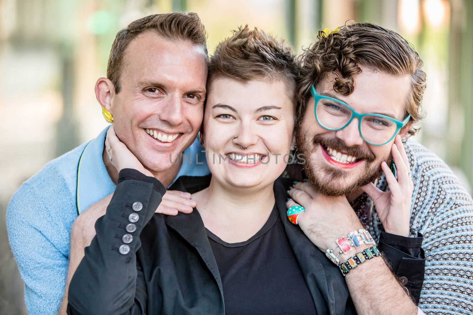 Three gender fluid friends pose and smile