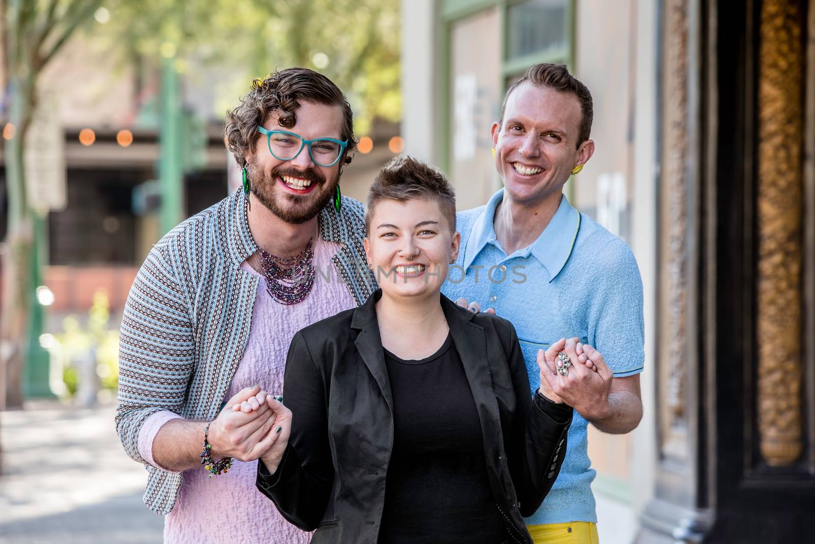 Three gender fluid young friends on an urban sidewalk