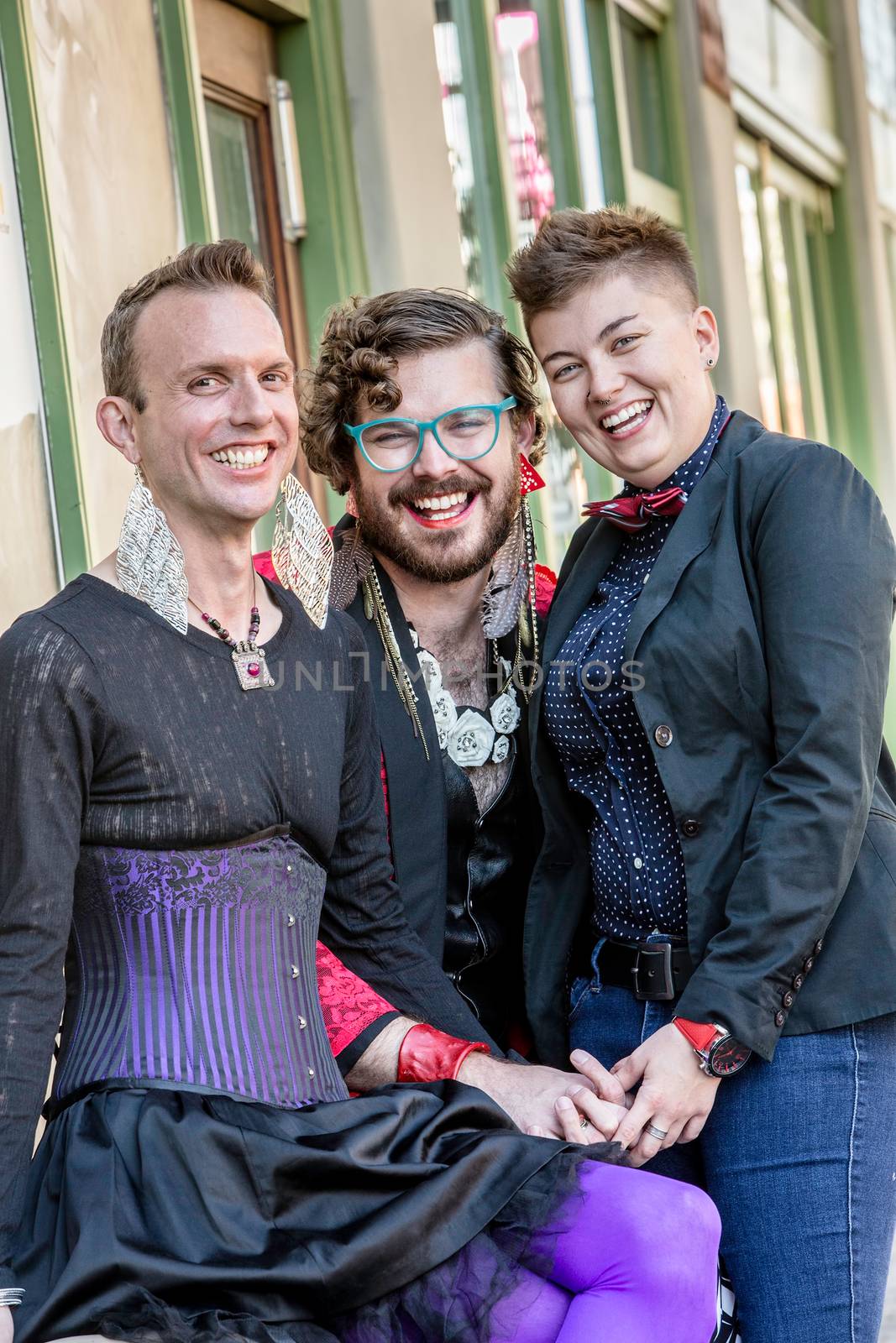 Grinning gender fluid trio of young friends