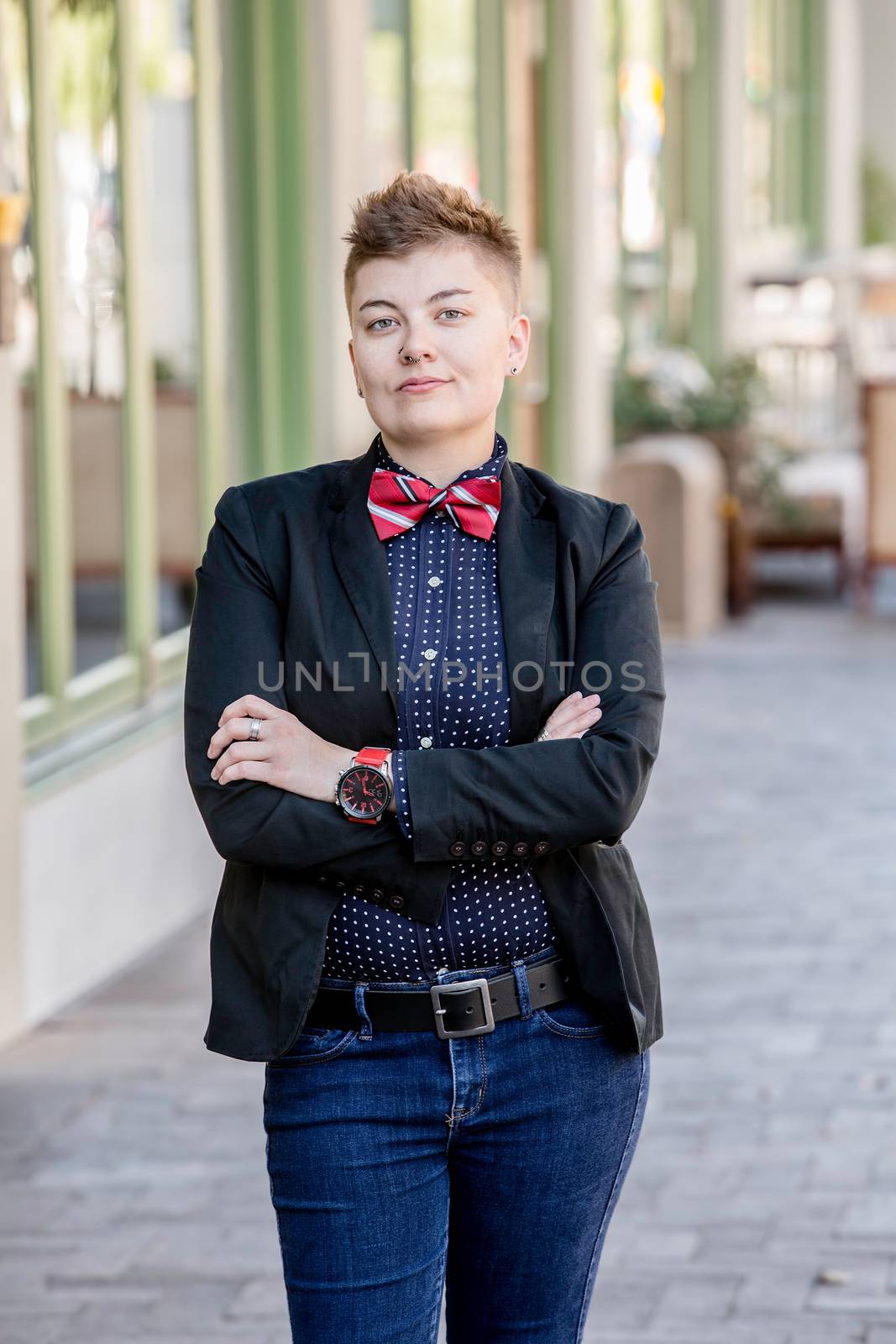 Serious dapper young gender fluid woman with arms crossed