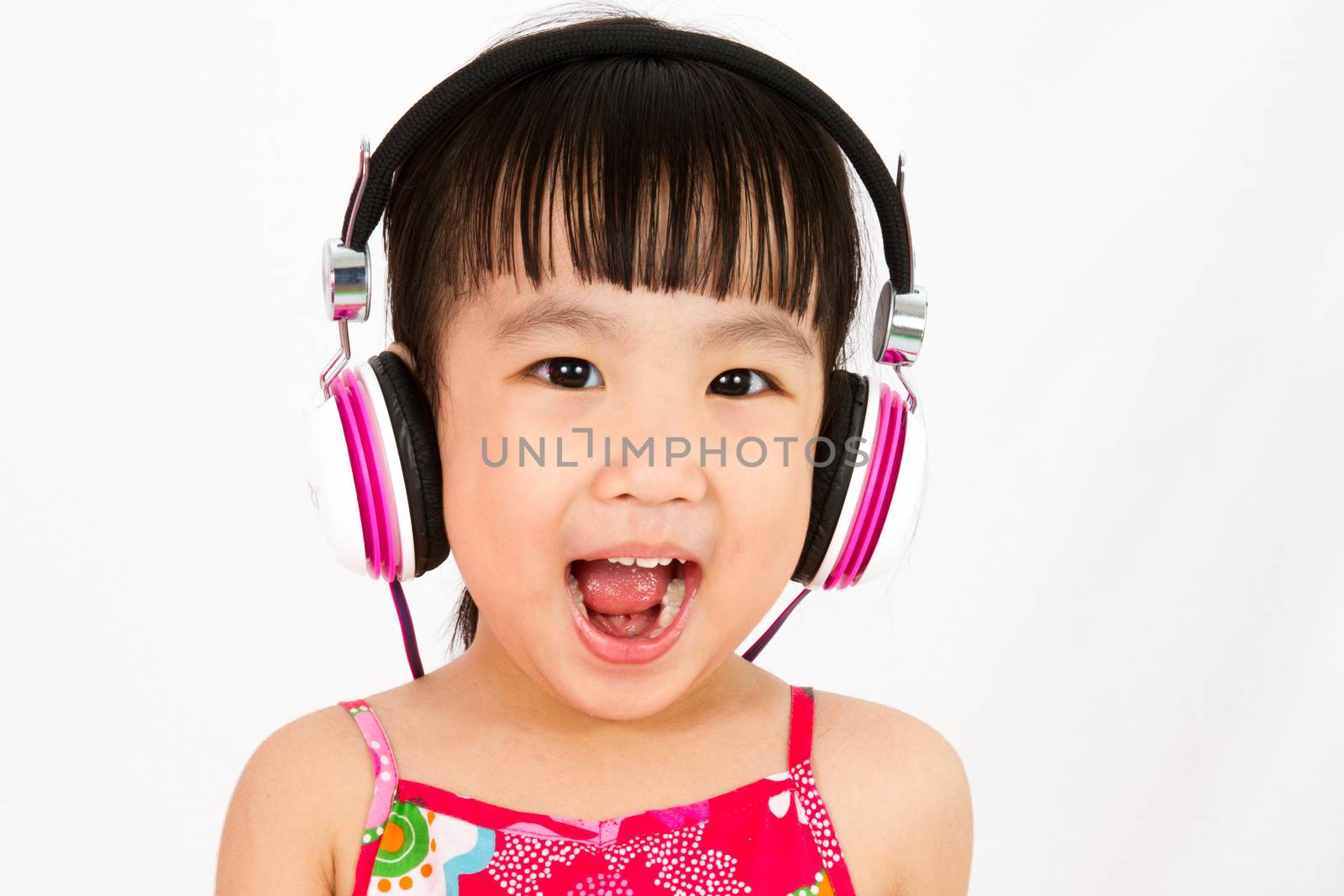 Chinese little girl on headphones with mouth open